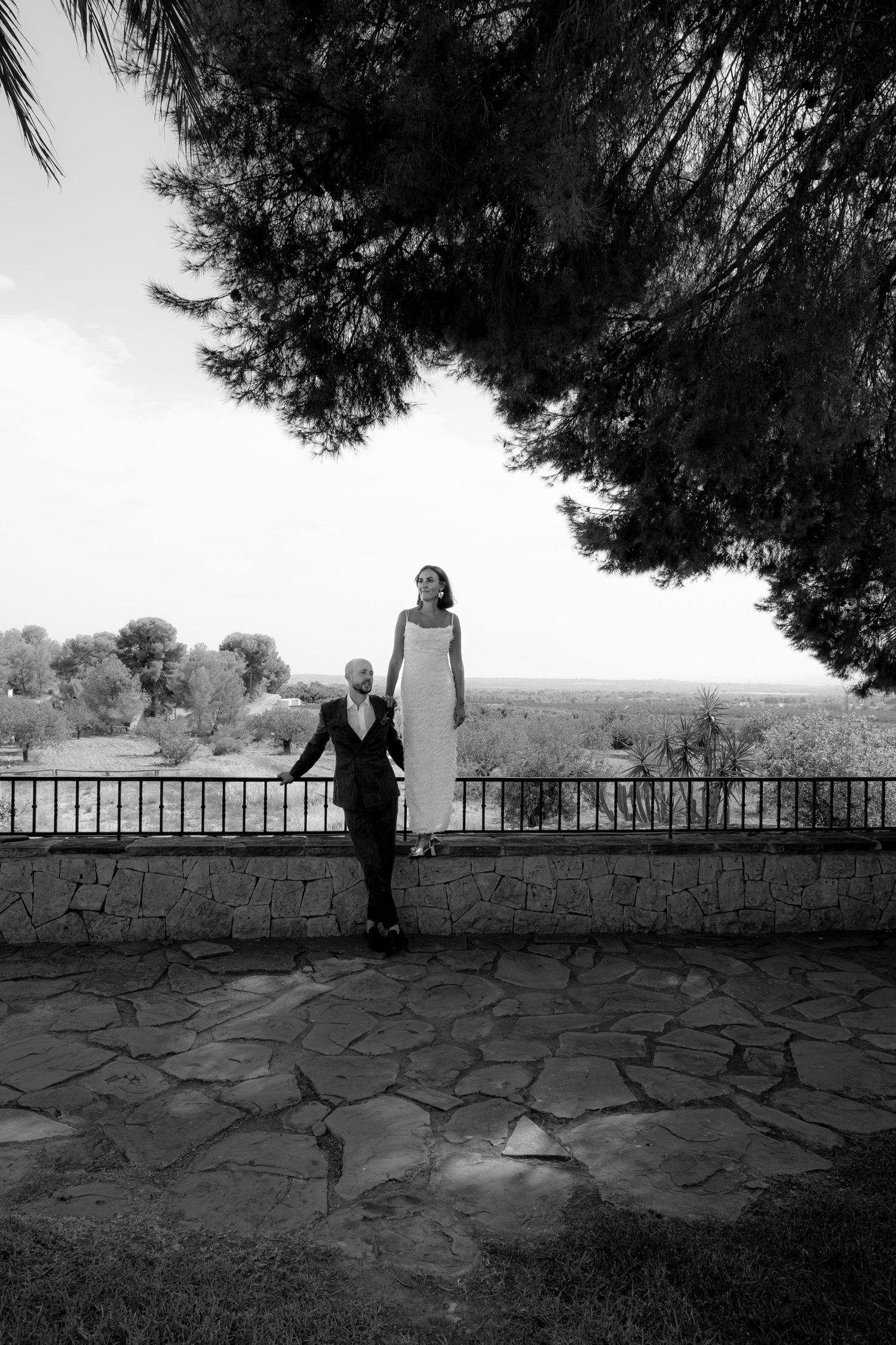 Black and white panoramic series showing silhouettes against a stone wall and railing.