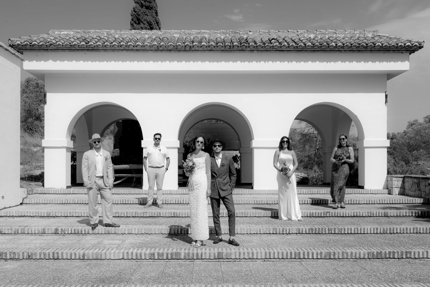 Black and white panoramic view of a Spanish colonial style building with arched walkway.