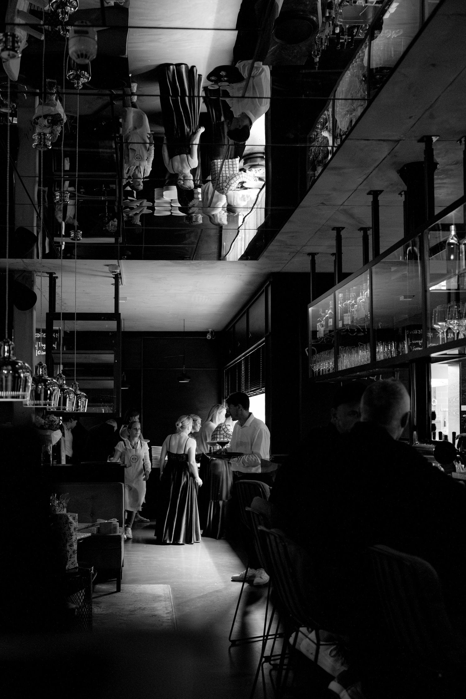 Atmospheric black and white photo of a wedding reception venue with dramatic lighting.