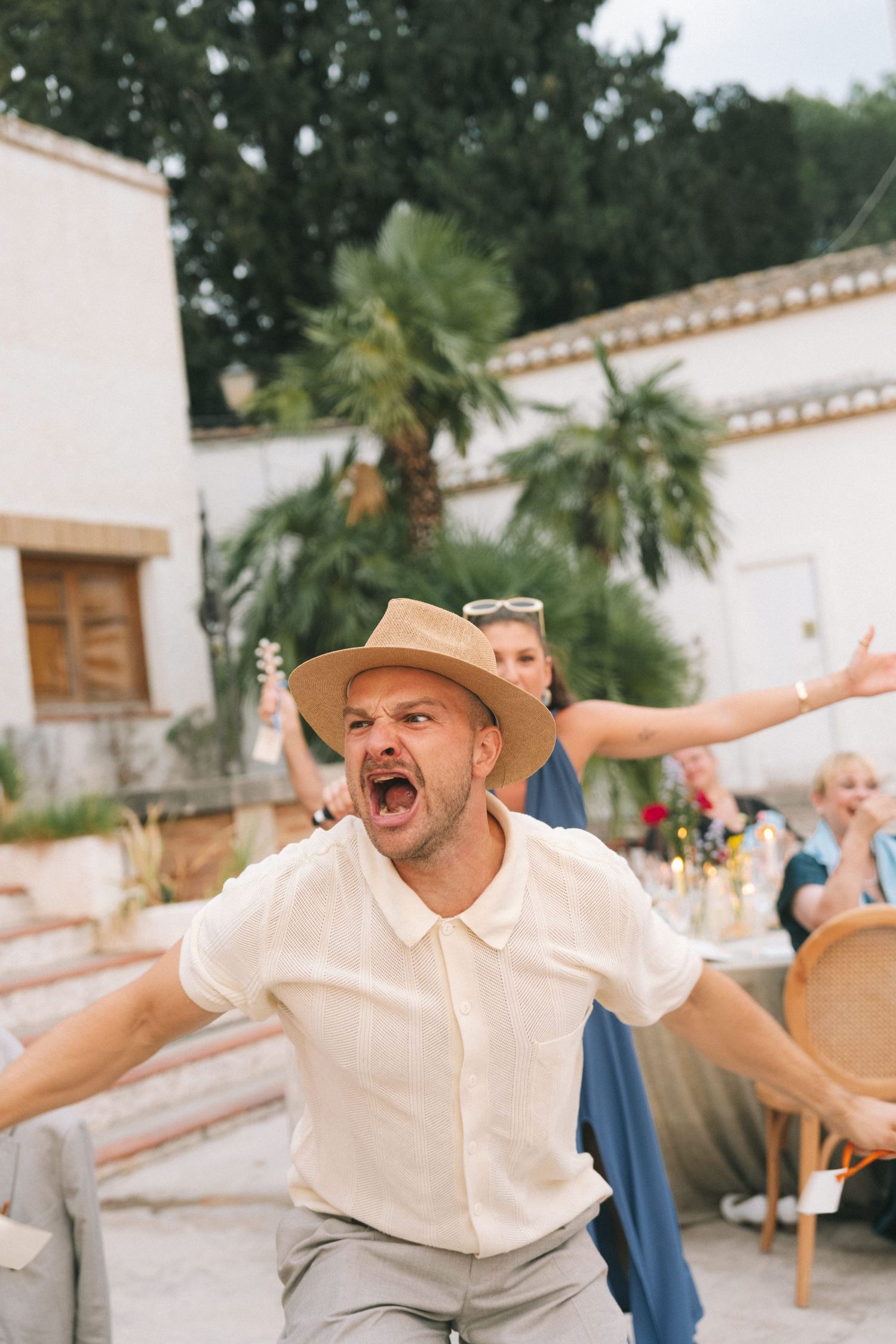 Guest celebrating enthusiastically at an outdoor wedding reception.