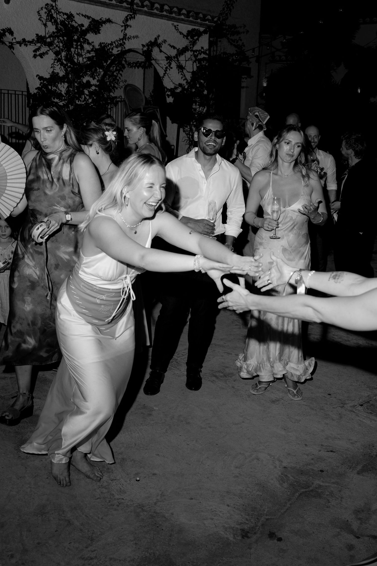 Wedding guests dancing and having fun on the dance floor at night.