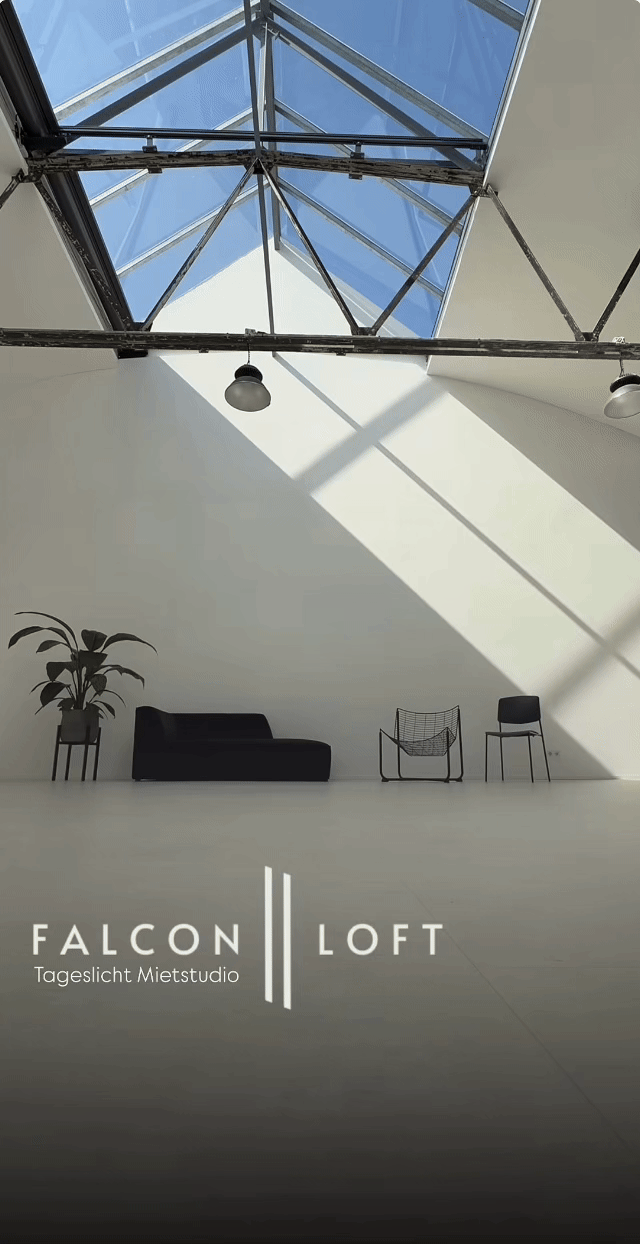 Modern photography studio interior with skylights and Falcon Loft branding on a minimalist grey wall.