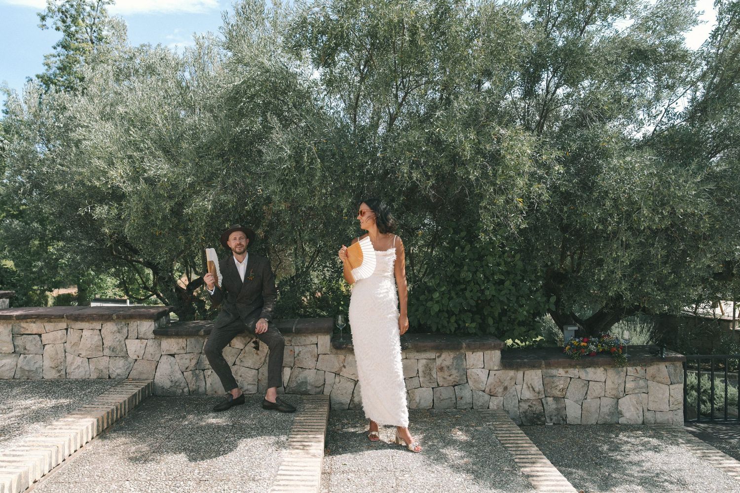Series of outdoor photos with olive trees and stone wall in background.