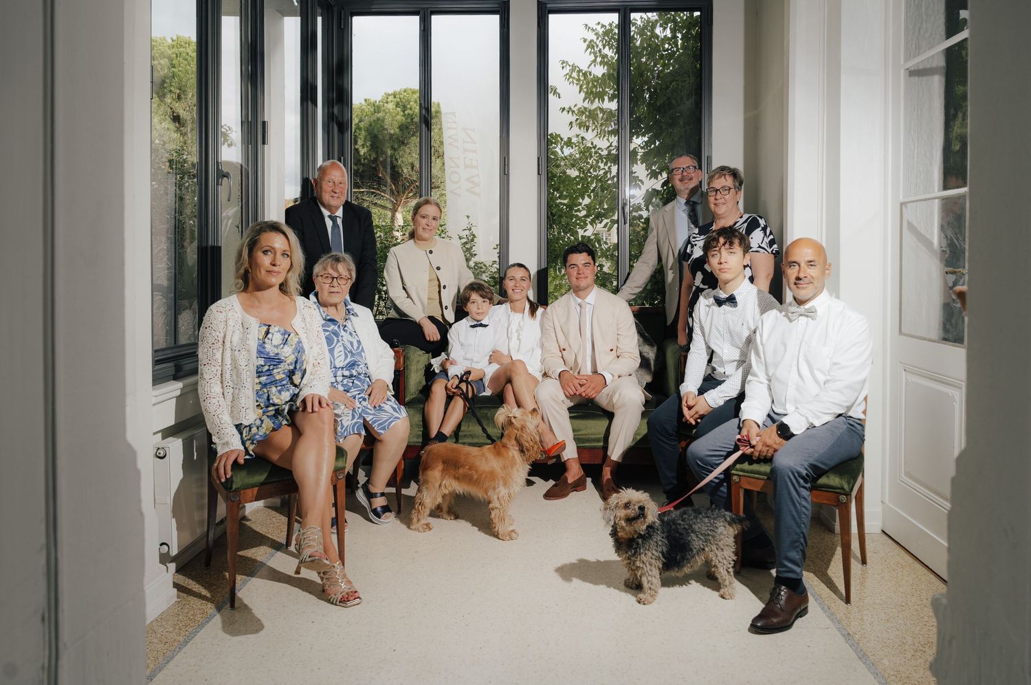 Wedding guests seated in a bright, modern space with large windows.