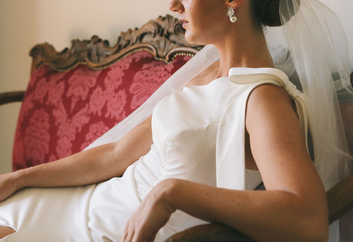 Close-up details of white wedding dress fabric and accessories.