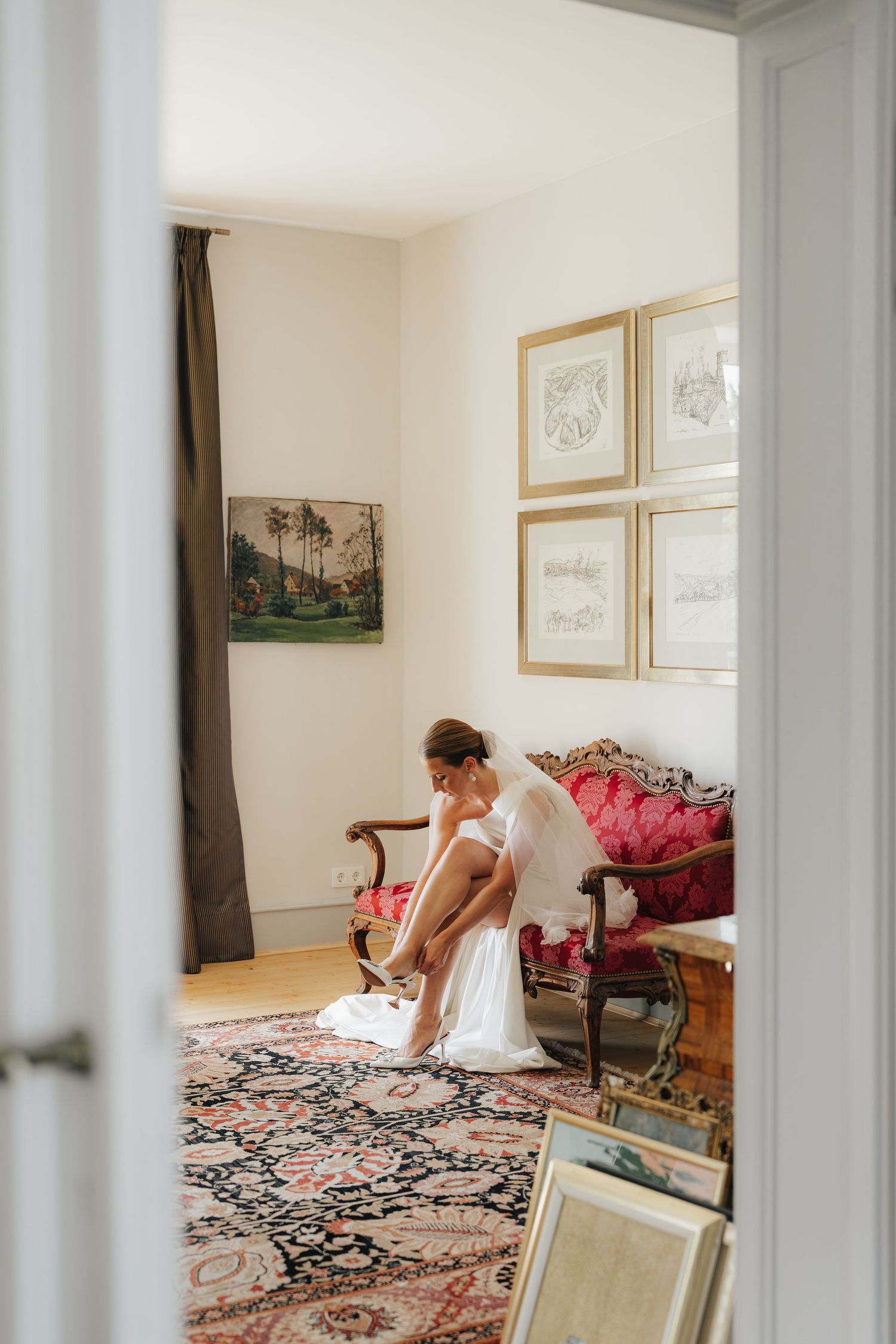 Wedding preparation scene in elegant room with antique furniture and oriental carpet.