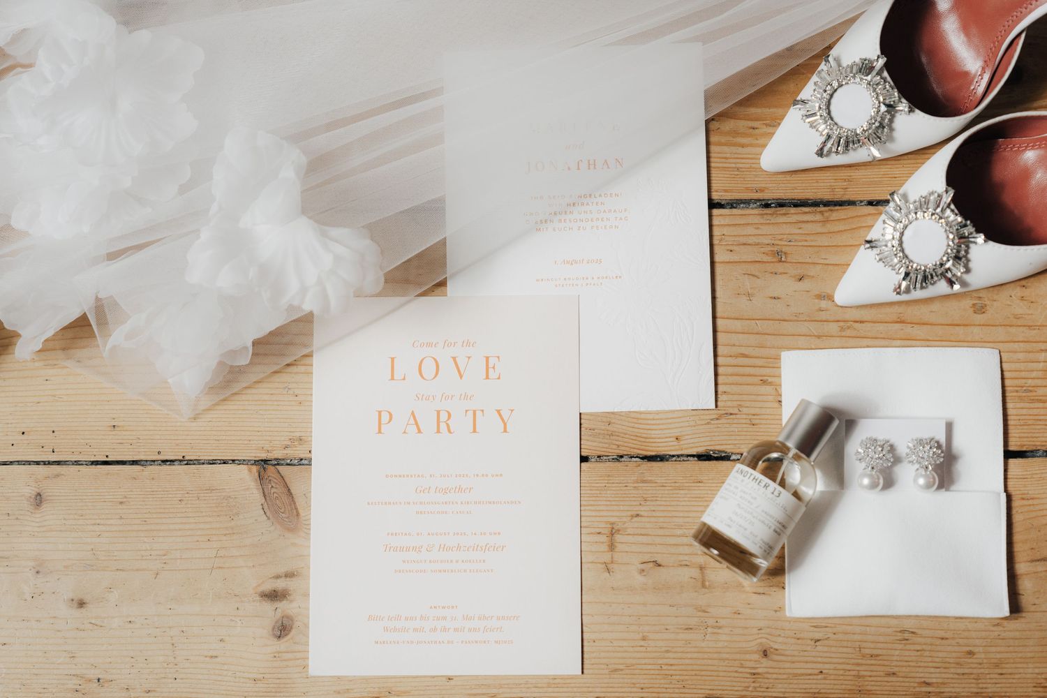 Wedding stationery and invitation details arranged on a wooden surface.