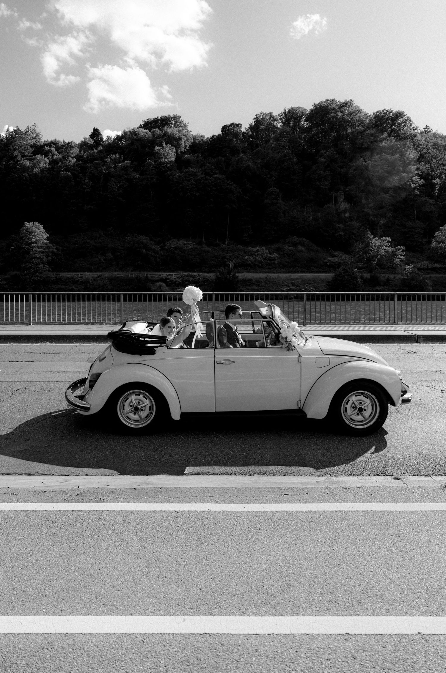 Vintage yellow convertible photographed in black and white against a scenic backdrop.