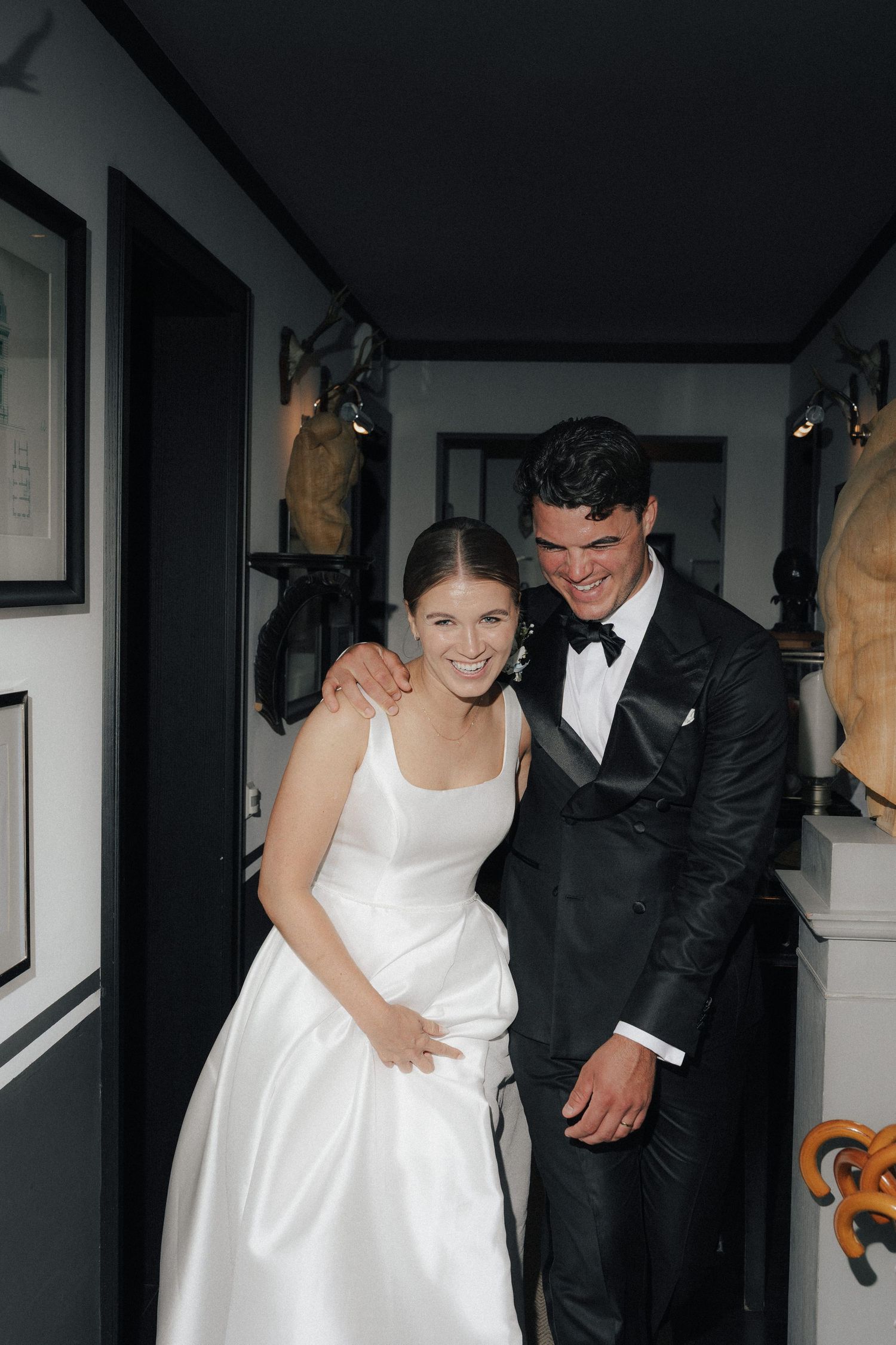 A wedding couple shares an intimate moment in a dimly lit indoor setting.