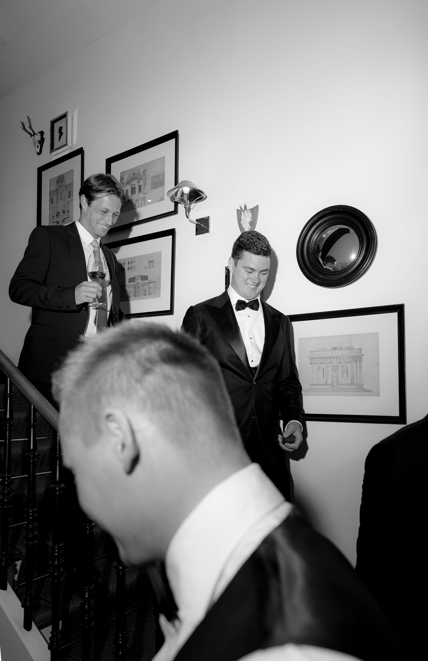 Black and white candid photos in an interior room with wall decorations.