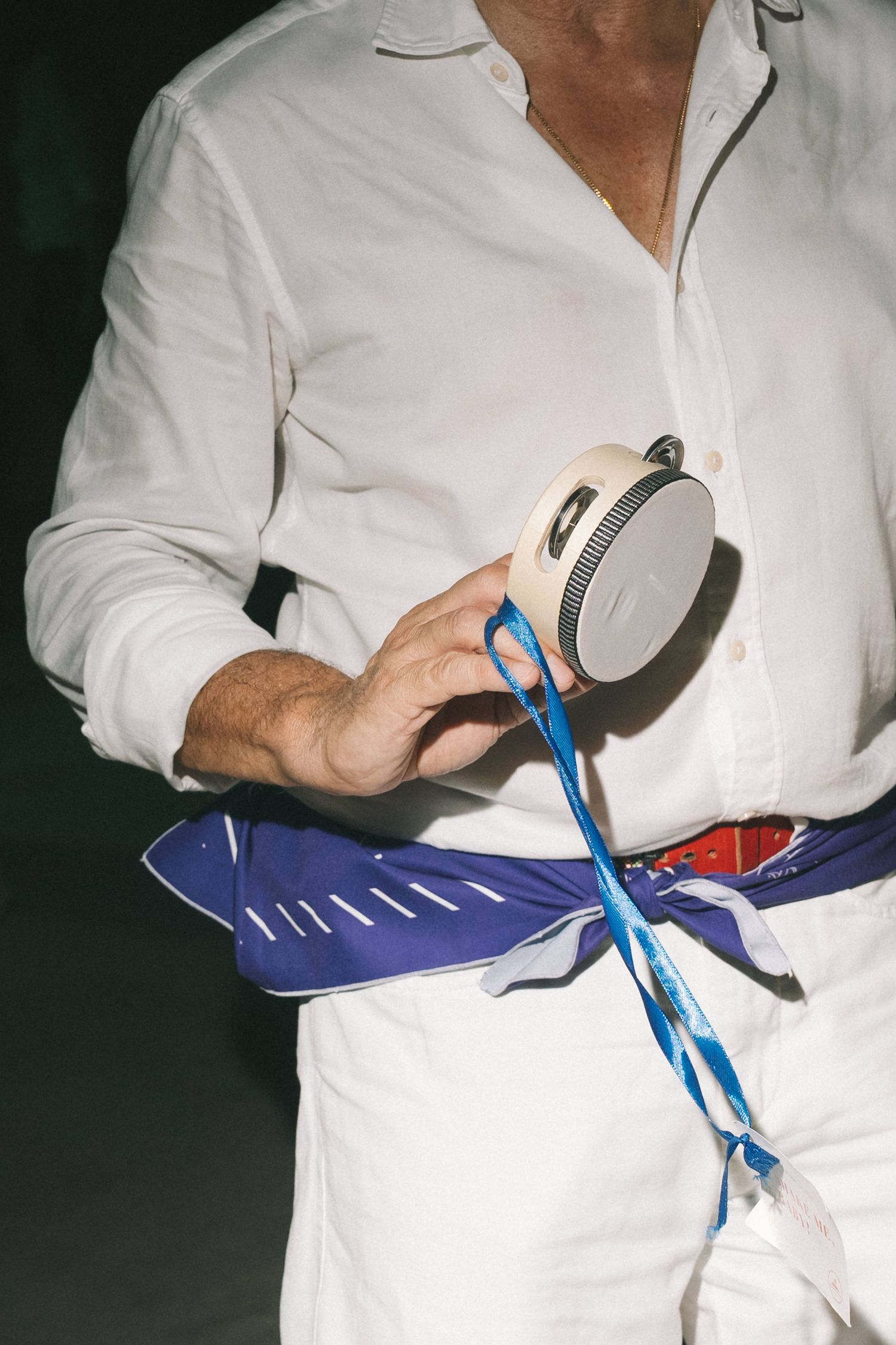 Person in white shirt untying a blue tie at a formal event.