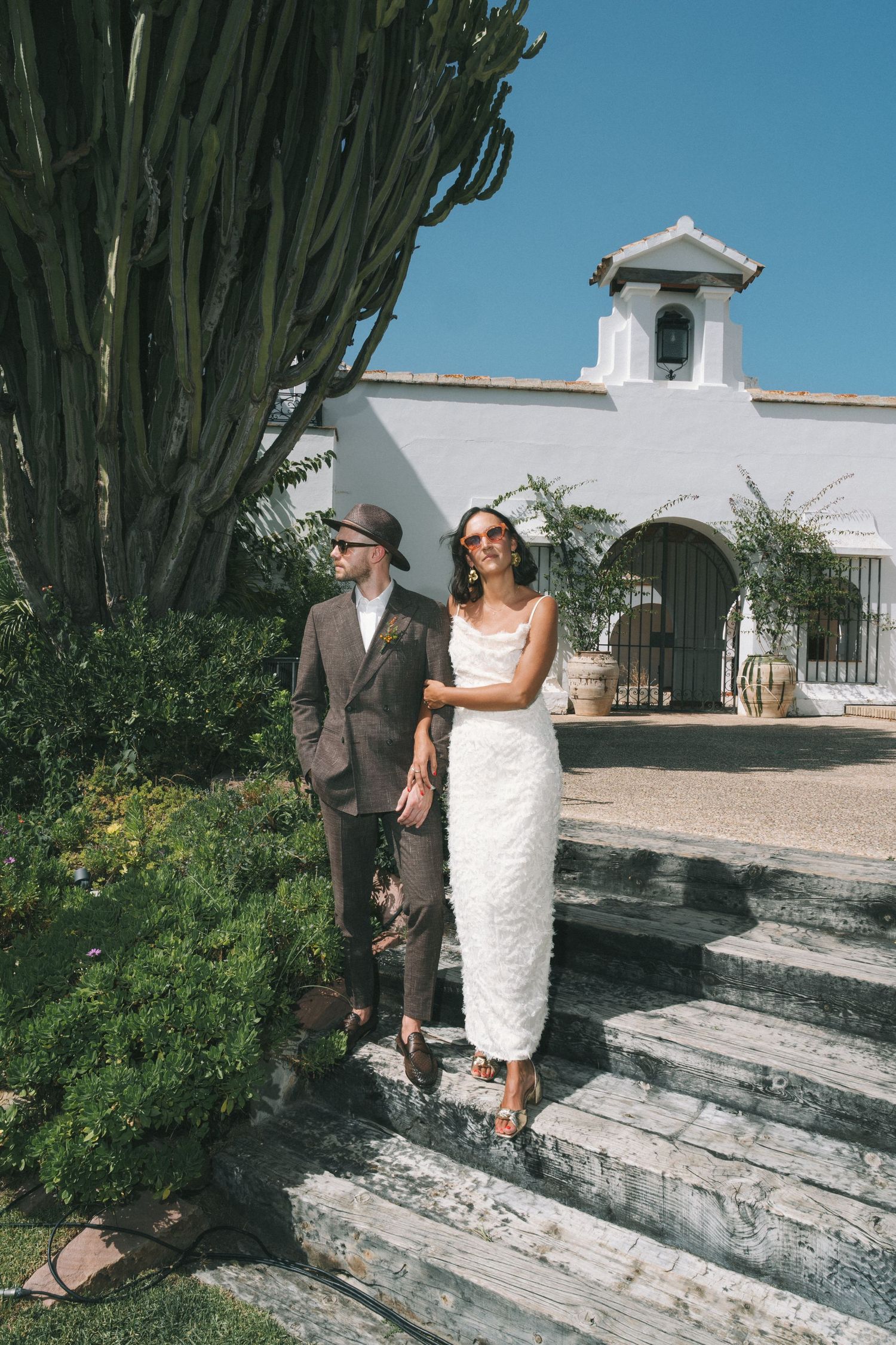 Photo sequence near white building with large cactus and stone steps.