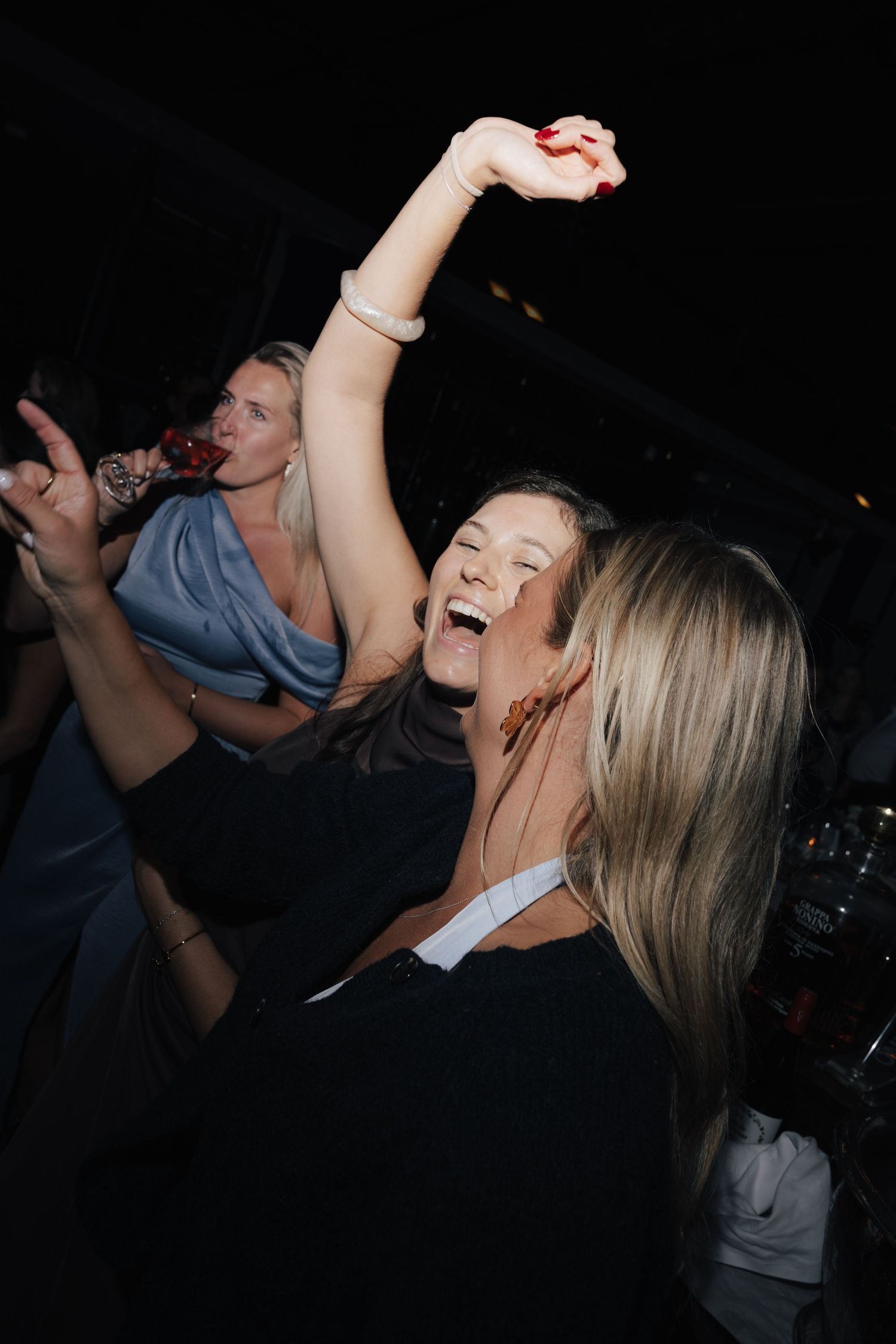 People dancing and celebrating enthusiastically at a nighttime event.