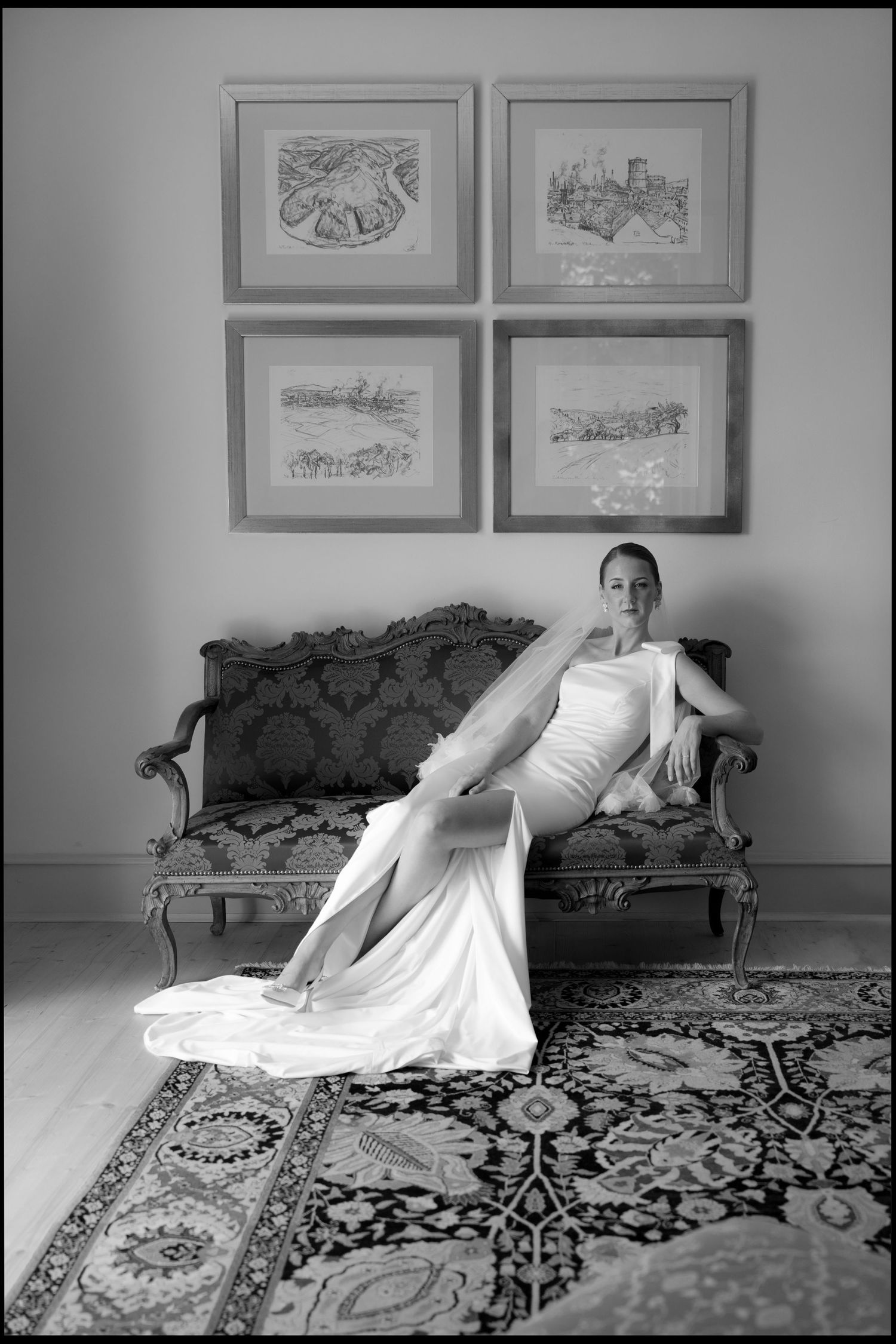 Classic bridal portrait in black and white with vintage sofa and framed artwork.