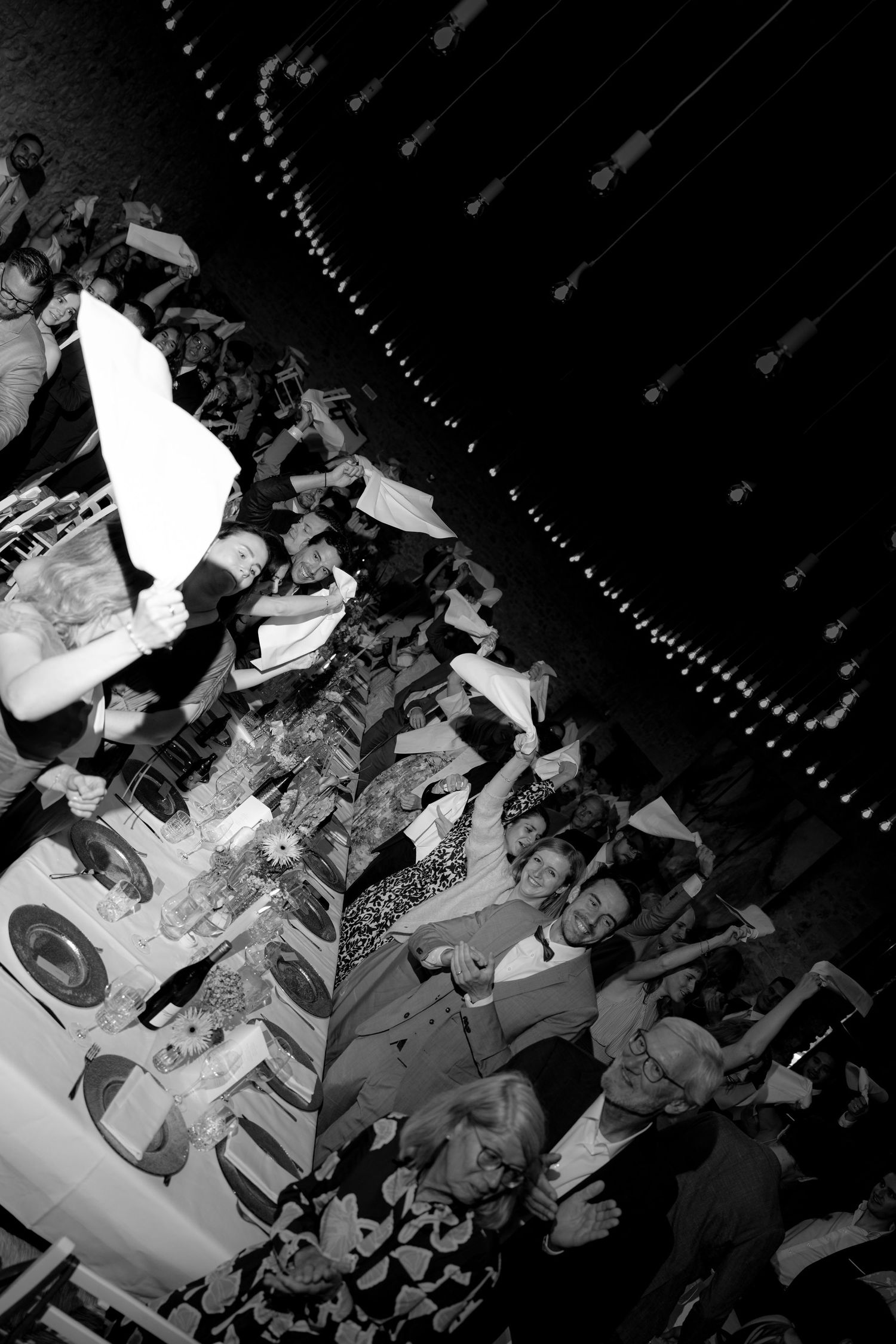 A crowded dance floor filled with guests celebrating at a nighttime event.