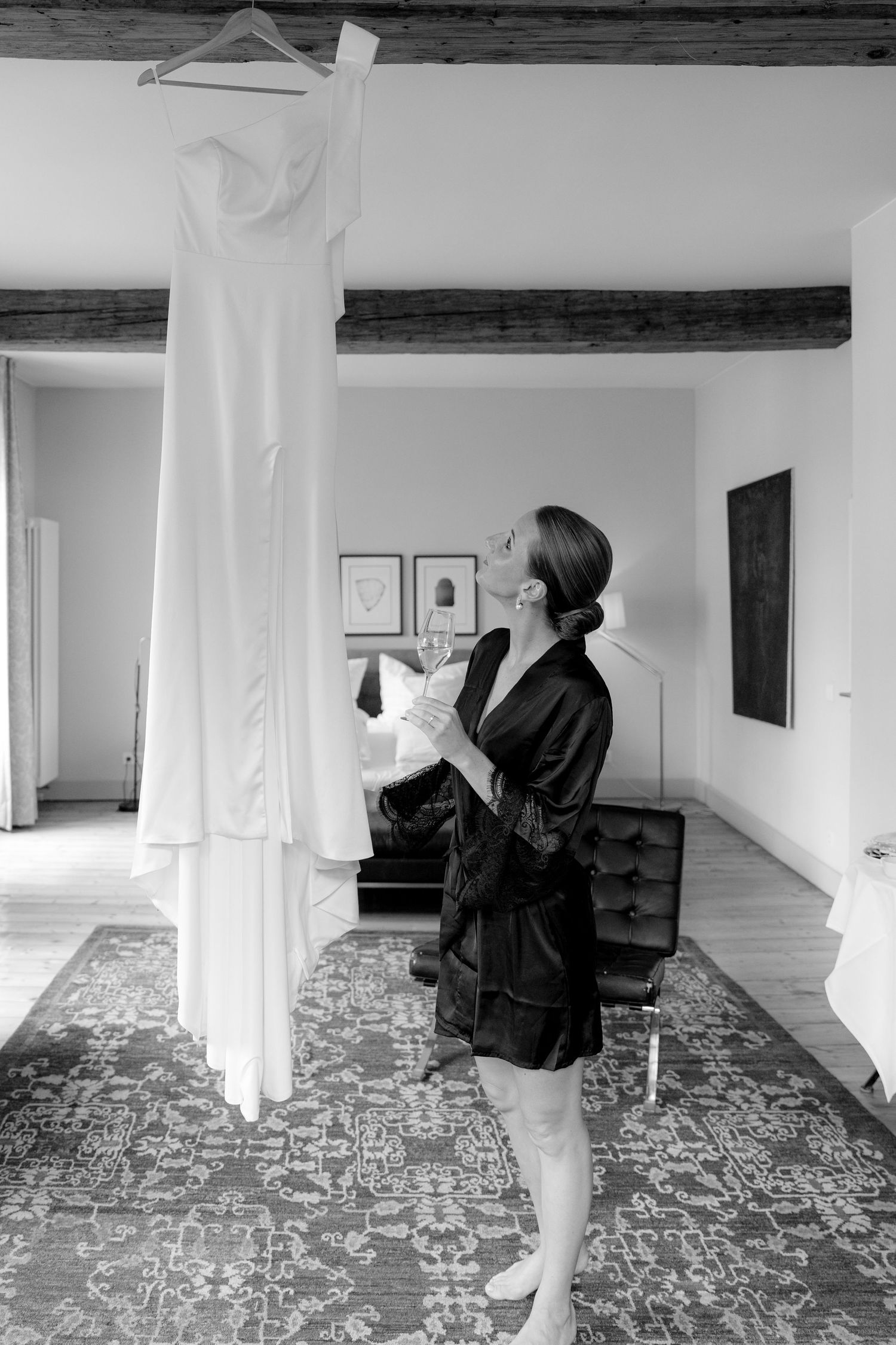 Black and white series showing someone reading papers in a minimalist room with patterned carpet.
