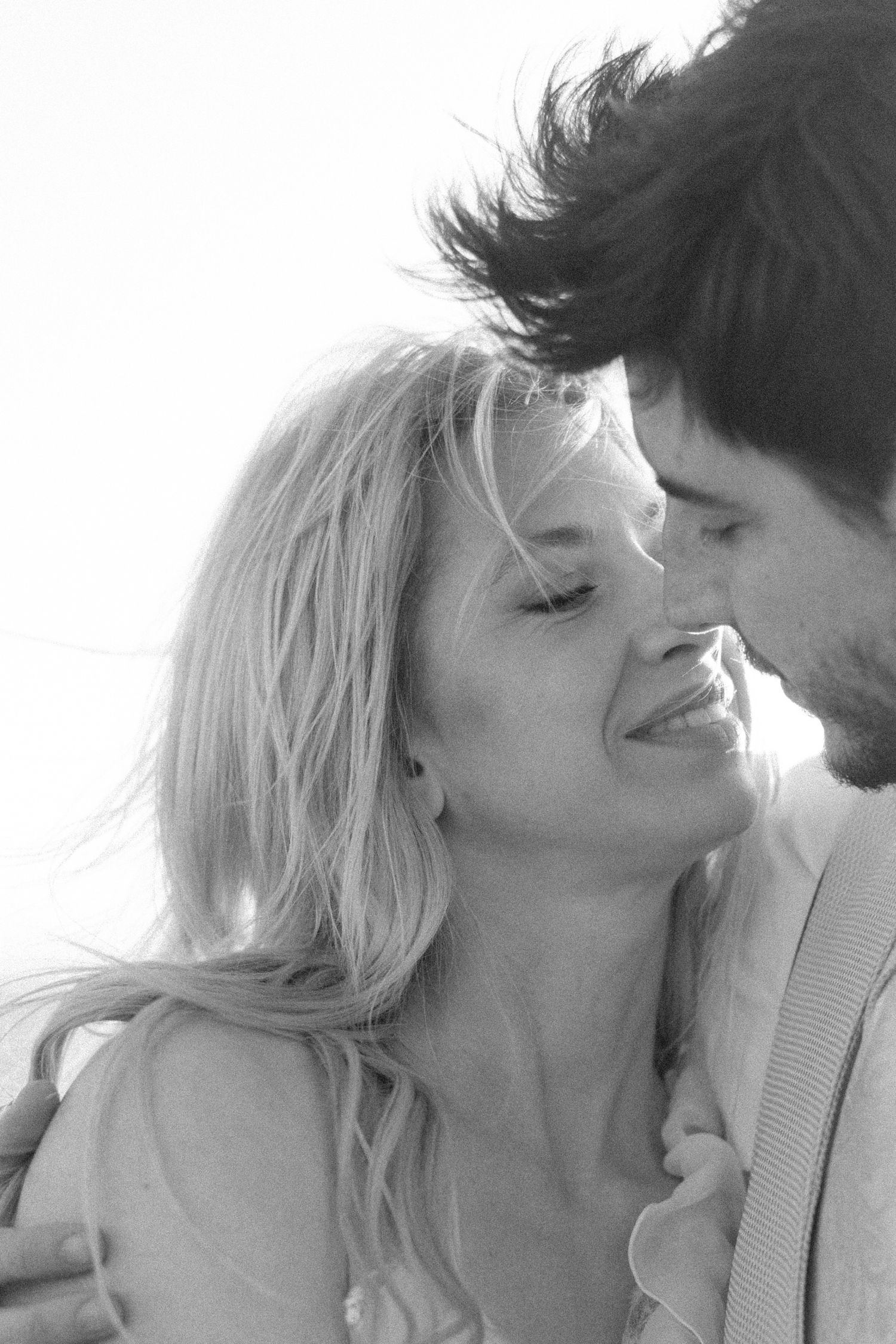A romantic black and white close-up portrait of a couple sharing an intimate moment.