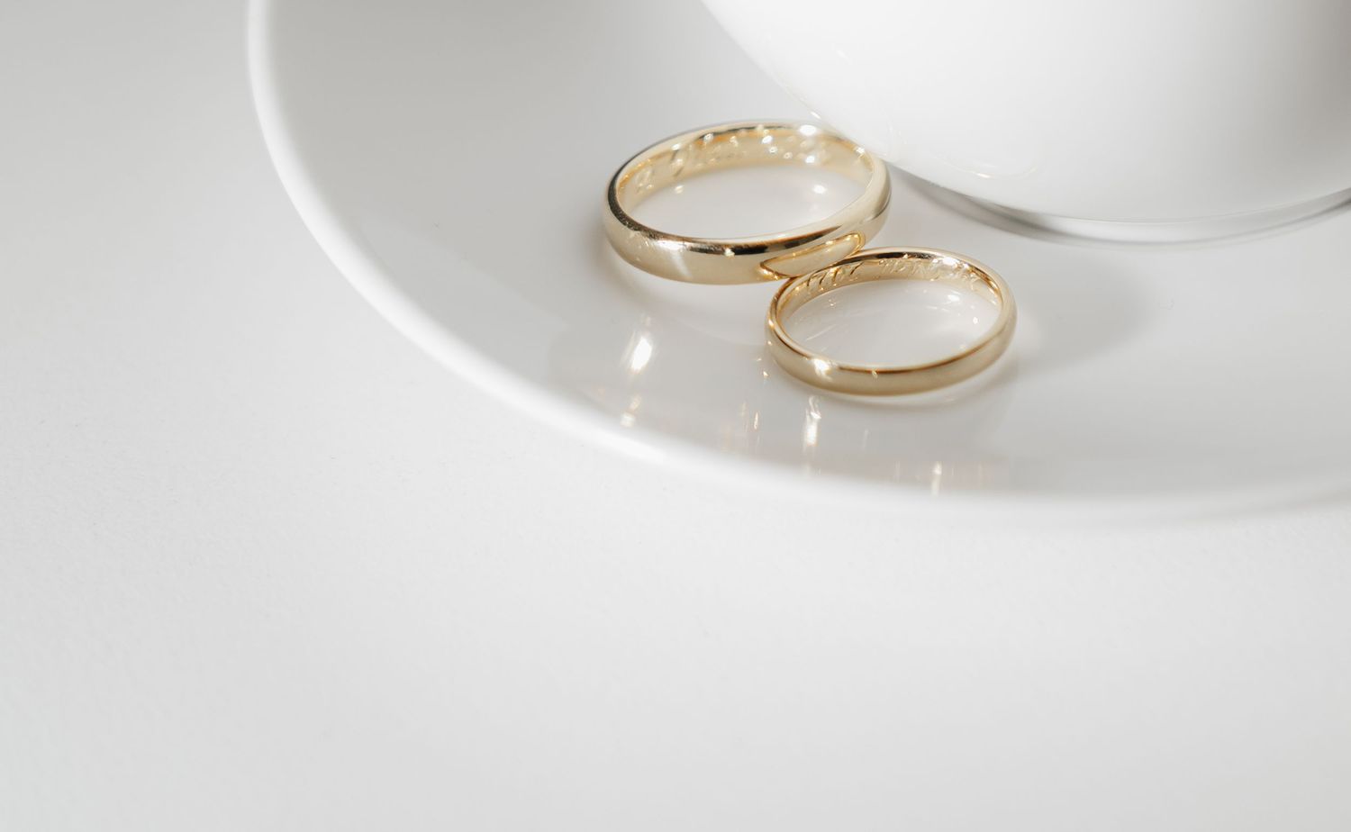 Multiple views of elegant gold wedding bands arranged on white background.