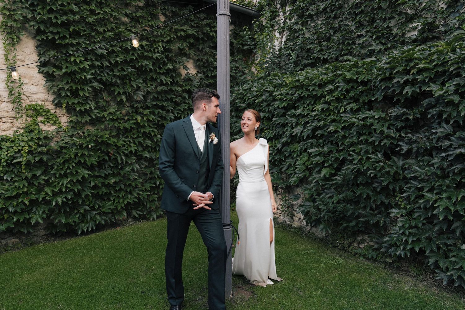 An elegant outdoor wedding setting with ivy-covered walls and natural greenery.