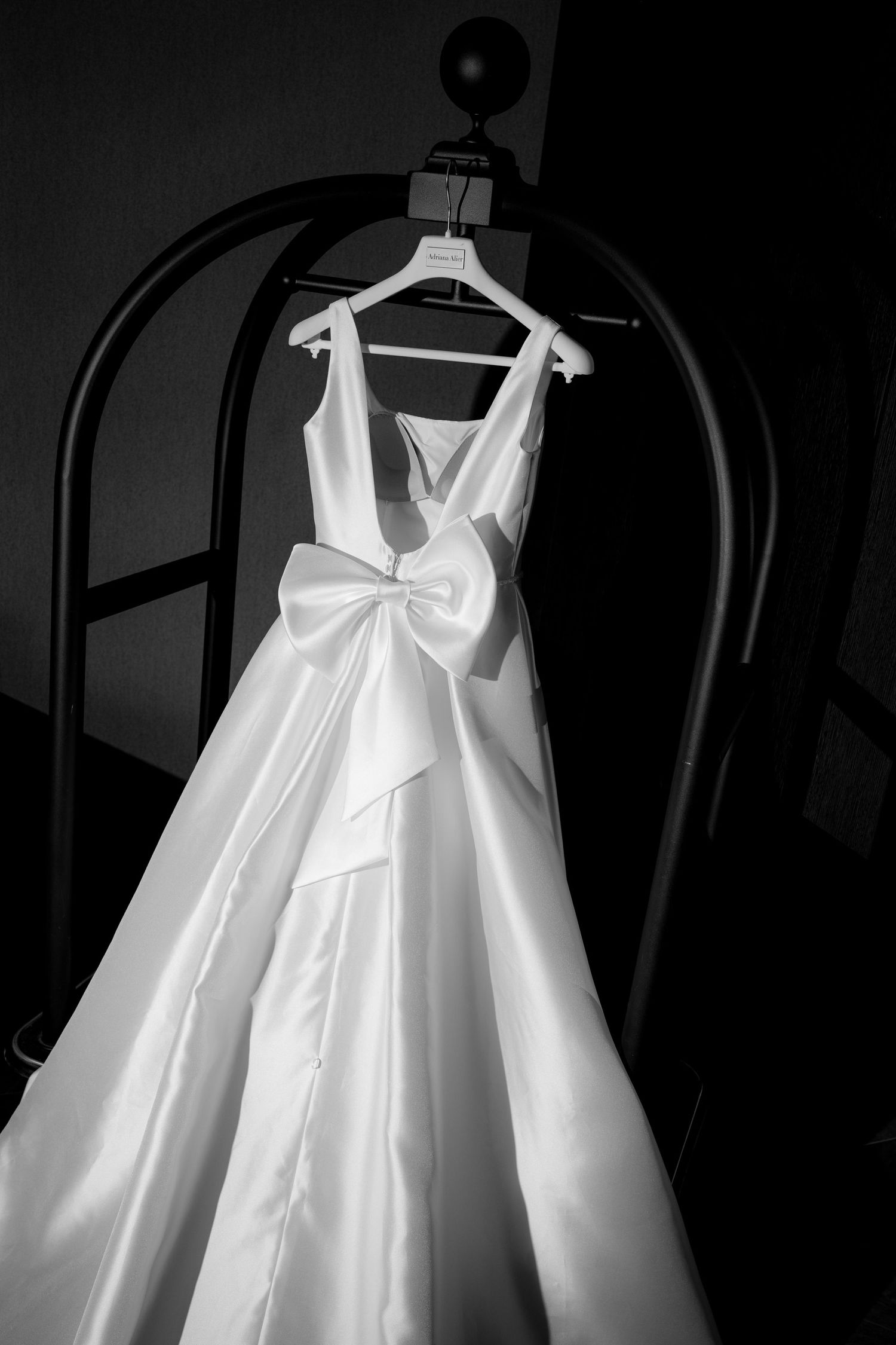 White wedding dresses hanging on display with elegant bow details.