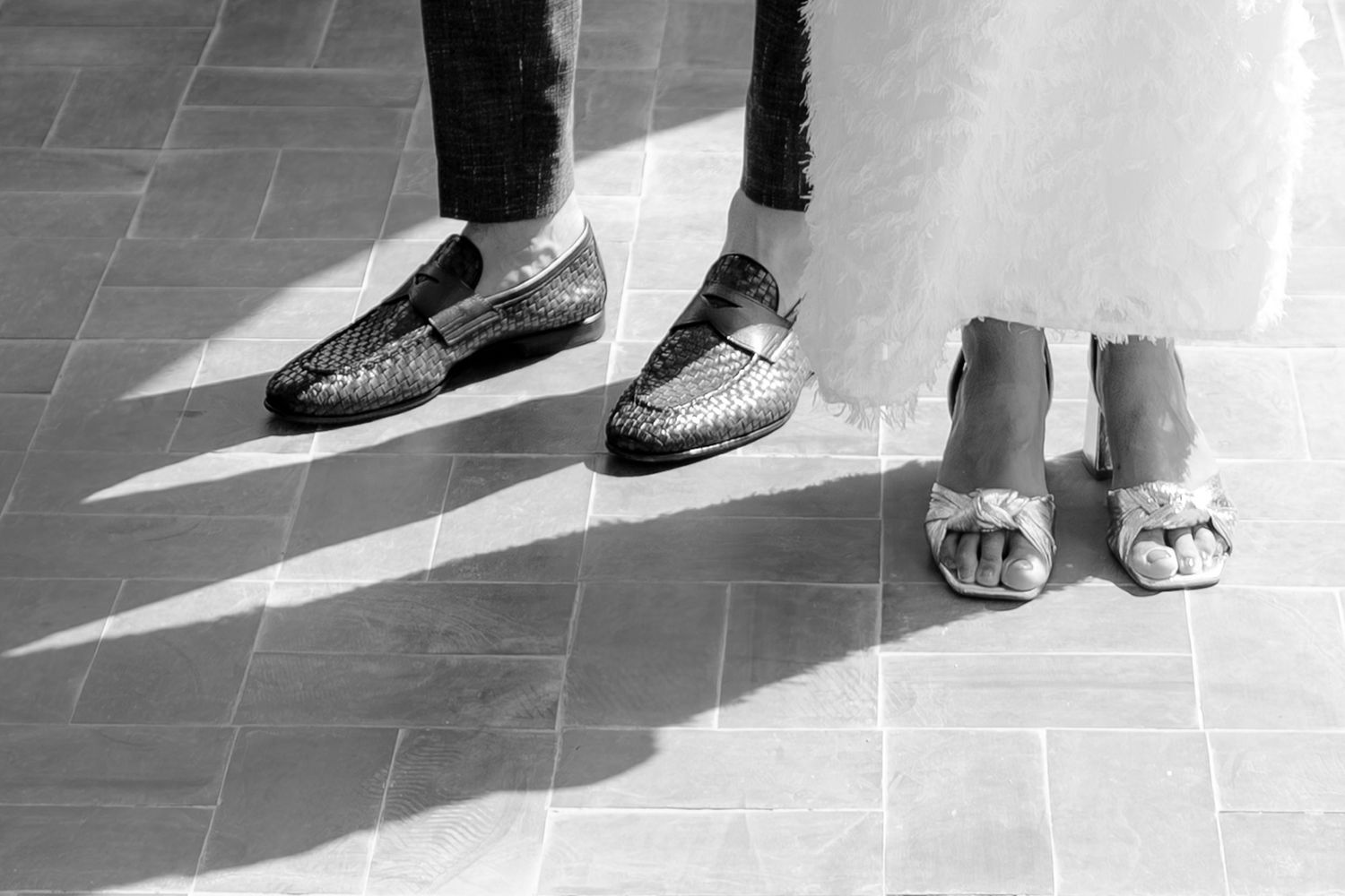 A sequence of black and white photographs showing various shoes and feet on a tiled floor.