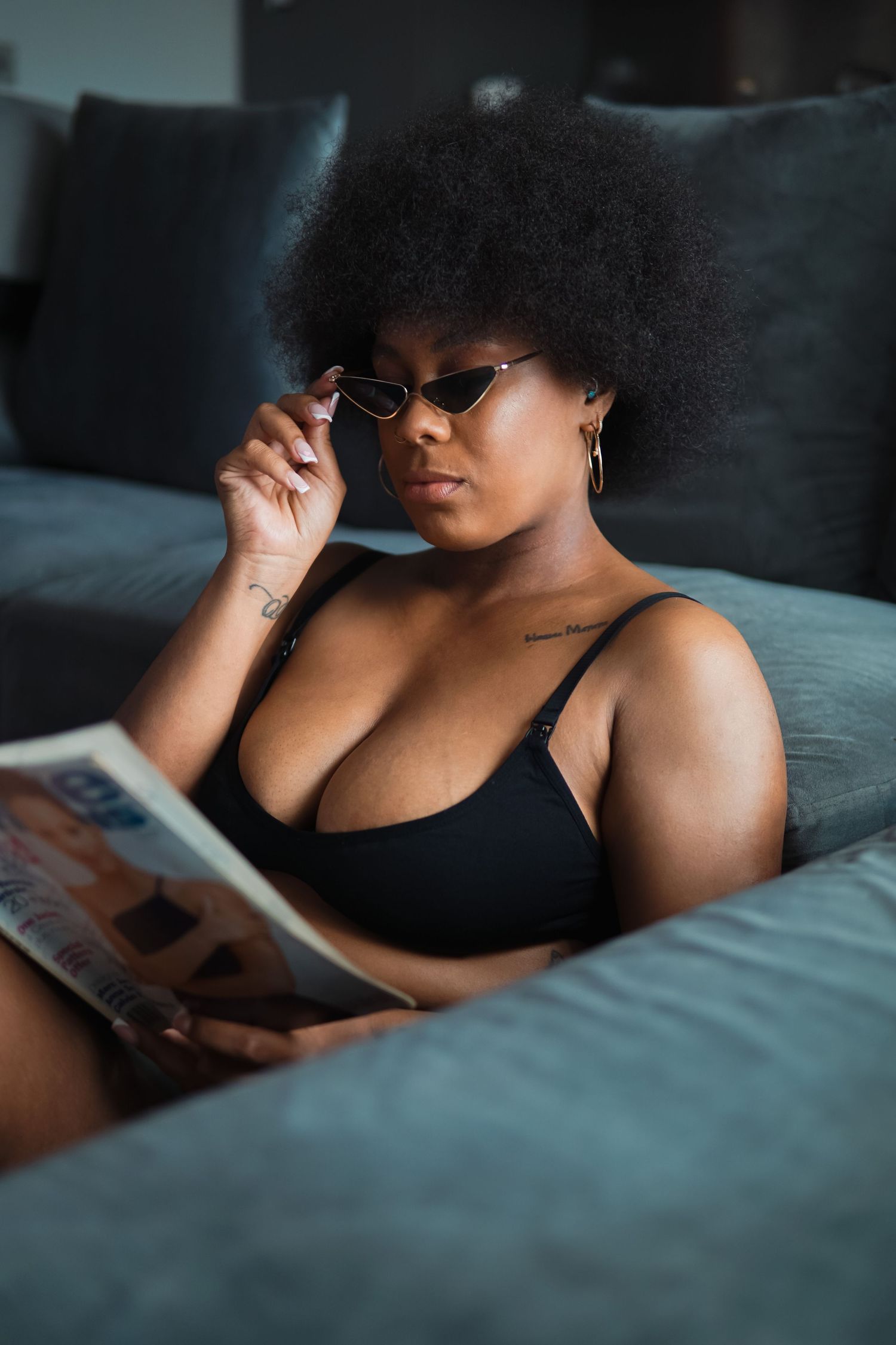 Woman with afro in tiny sunglasses reading a magazine Boudoir photography UK Liverpool