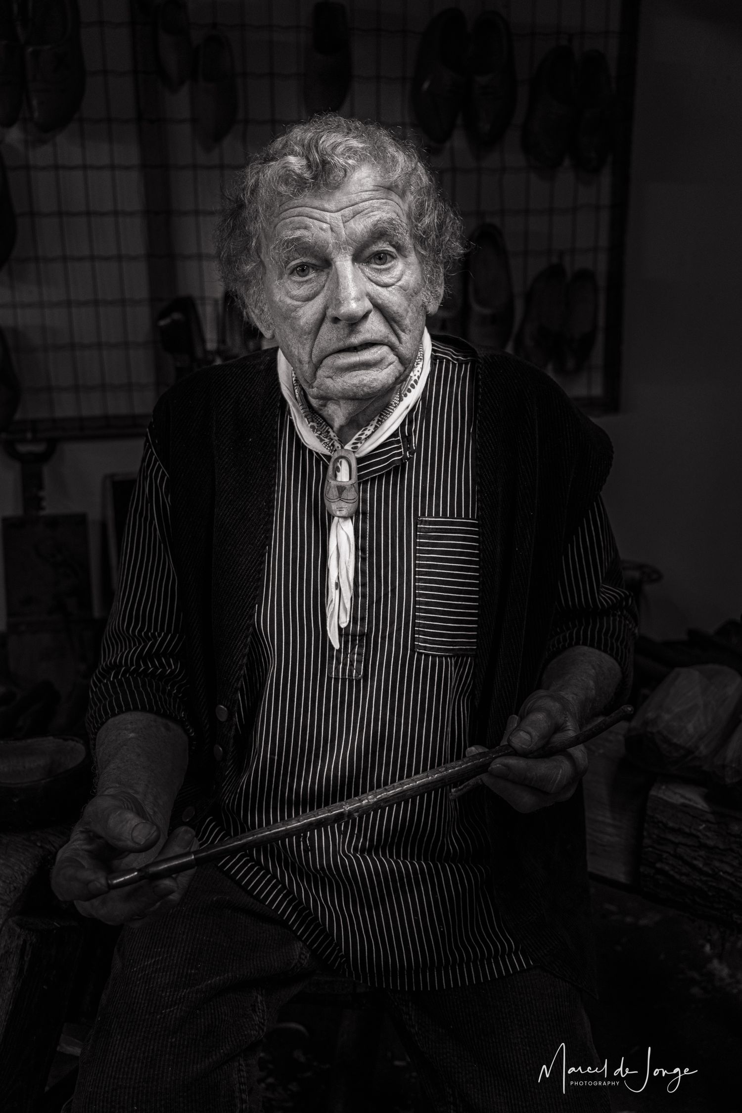 A black and white photo sequence showing an elderly person in a striped vest making expressive faces.
