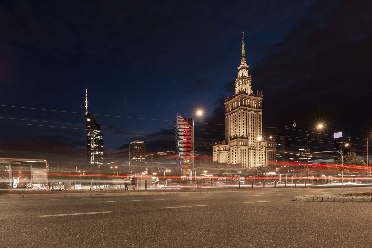 Night cityscape of Warsaw with illuminated Palace of Culture and Science and light trails from traffic on the street.