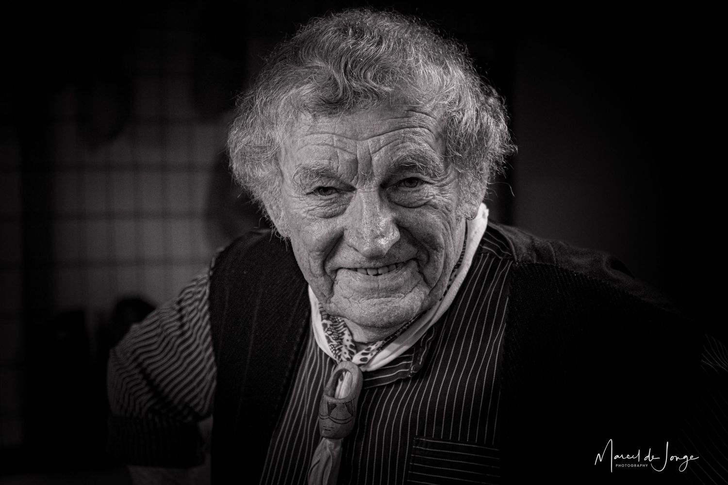 Black and white portrait series showing an elderly person's changing expressions from serious to joyful.