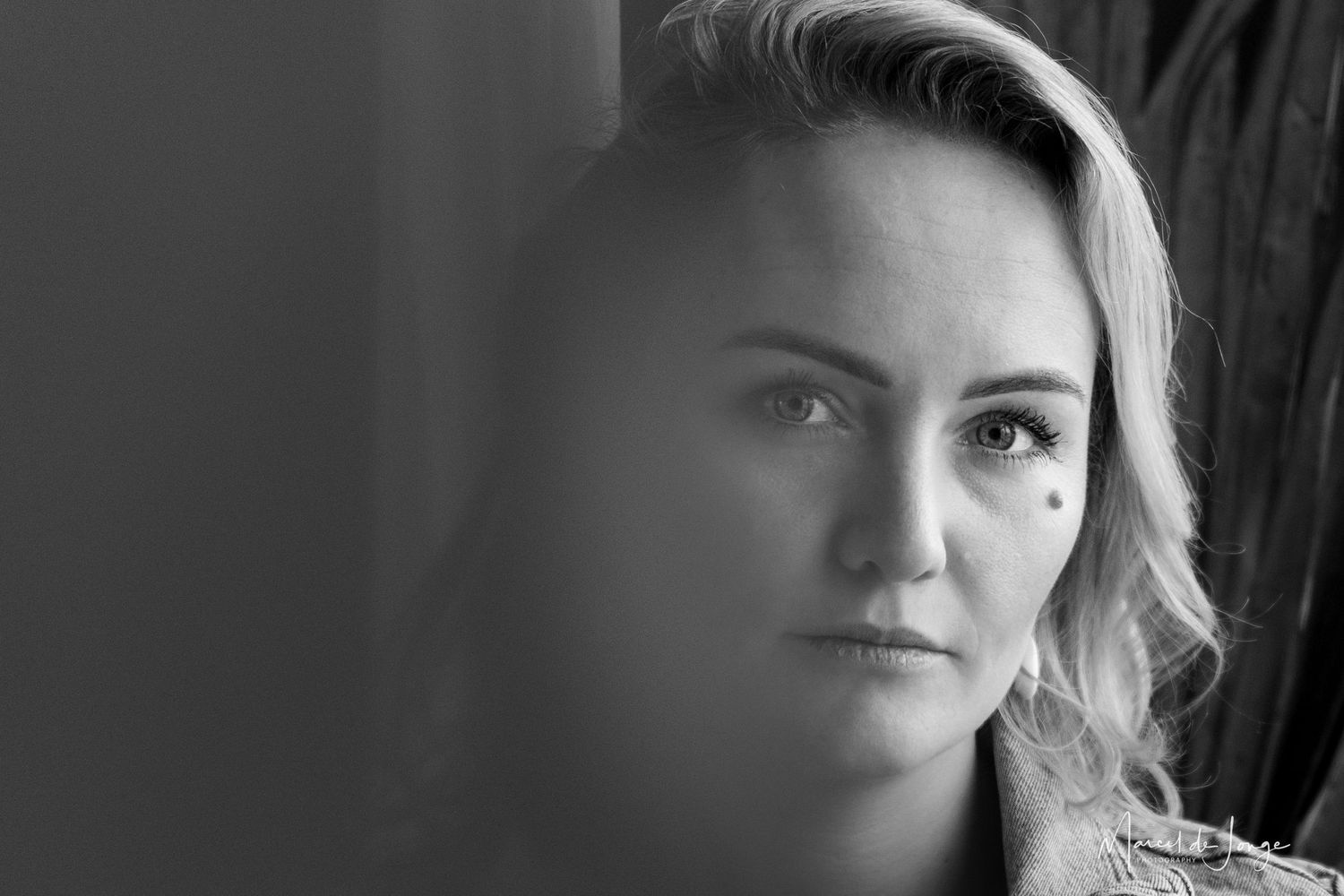 A black and white collage of seven close-up portrait shots showing different expressions and angles.