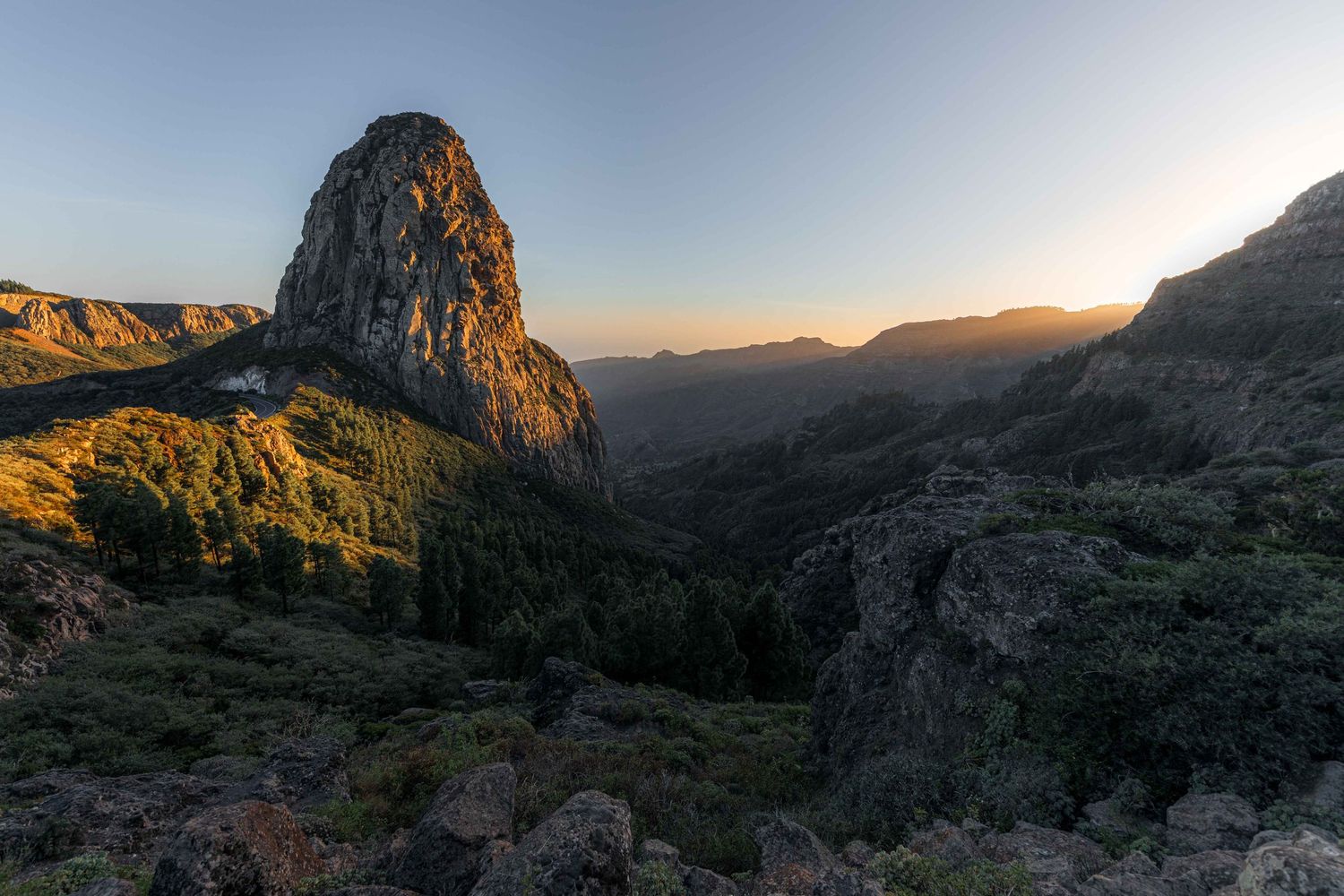 Dramatic sunset over rocky mountain peaks with lush green valleys below on La Gomera island, Canary Islands, Spain.