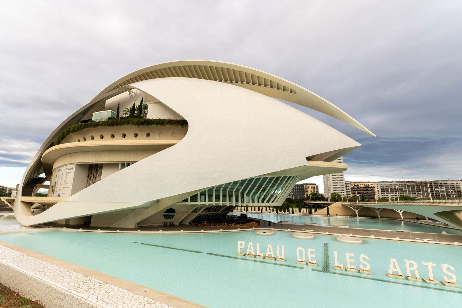Architectural details of the City of Arts and Sciences complex in Valencia featuring curved white modern structures and pools.