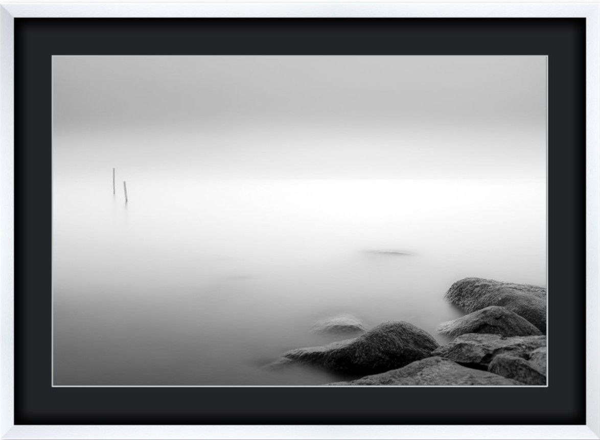 Dramatic black and white landscape photographs of misty mountains and rocky coastlines in minimalist style.