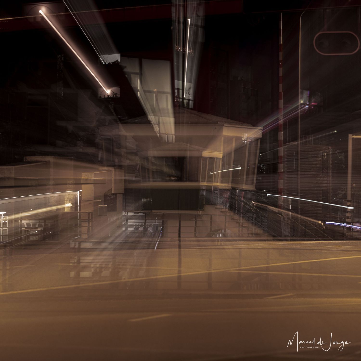 Long exposure photograph of an empty parking garage at night showing light trails and architectural lines.