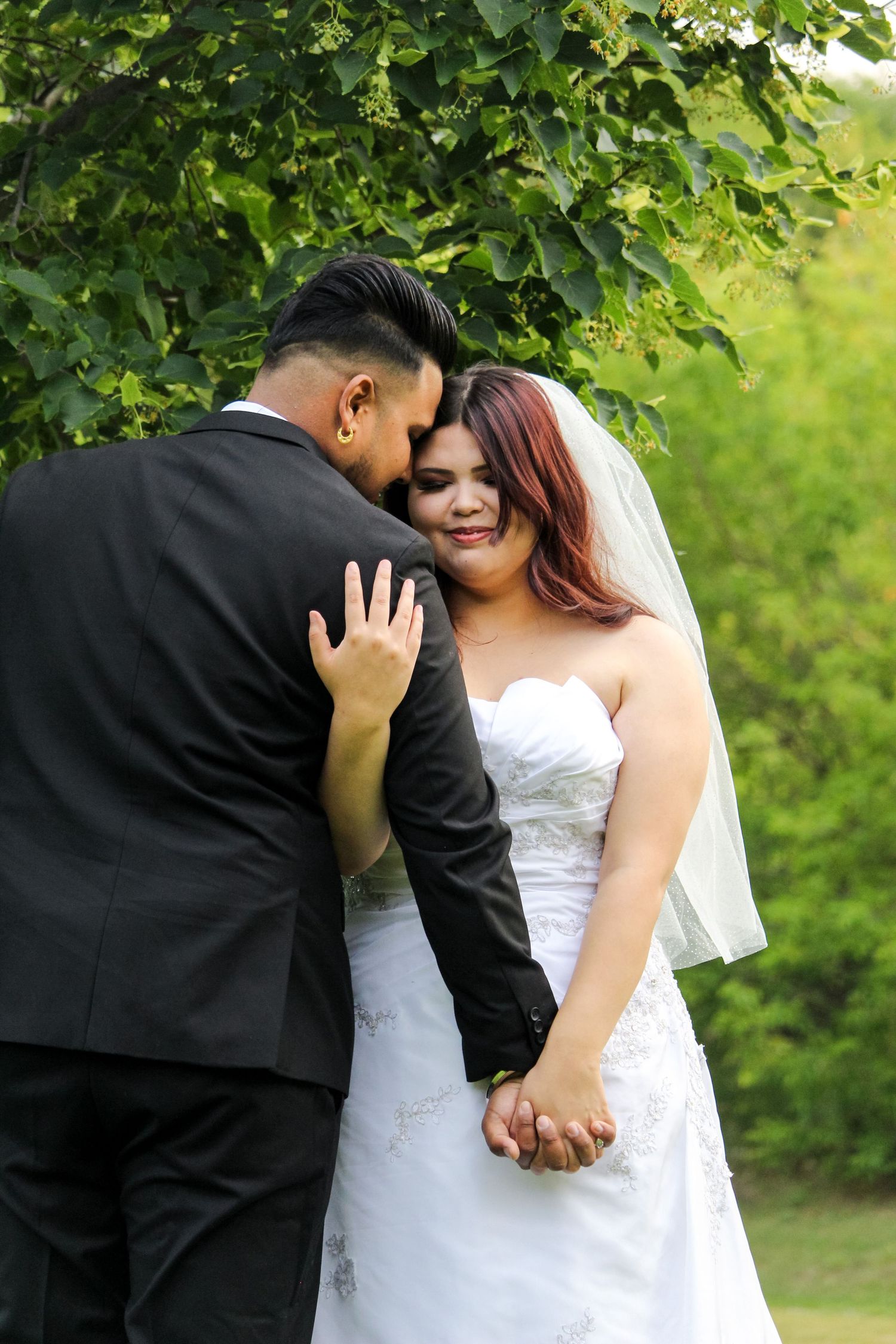 Man and Woman in wedding attire holding each other close in Peace River, AB