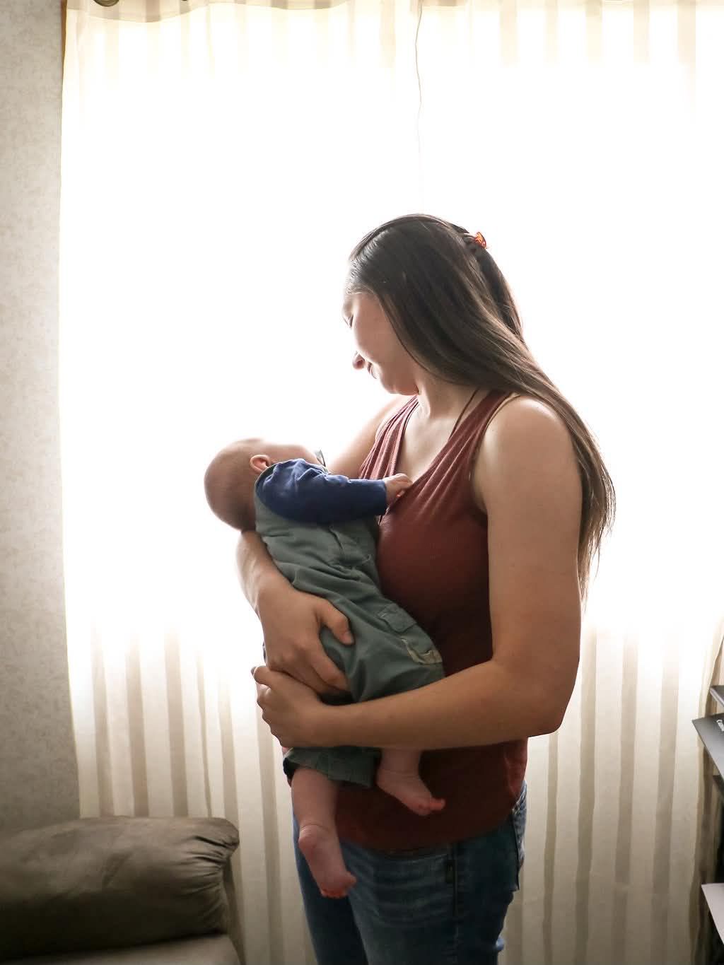 Woman holding and looking at baby in Berwyn, AB
