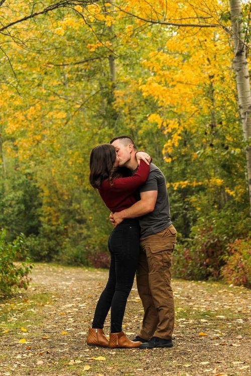 couple kissing in path with fall forest backround, Grimshaw, AB