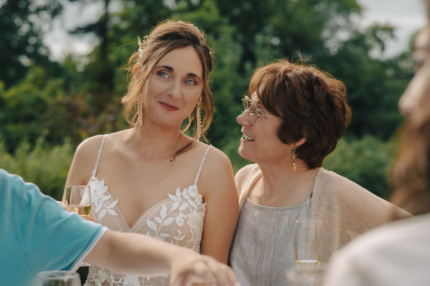 Wedding guests enjoying a casual outdoor celebration in summer garden setting.