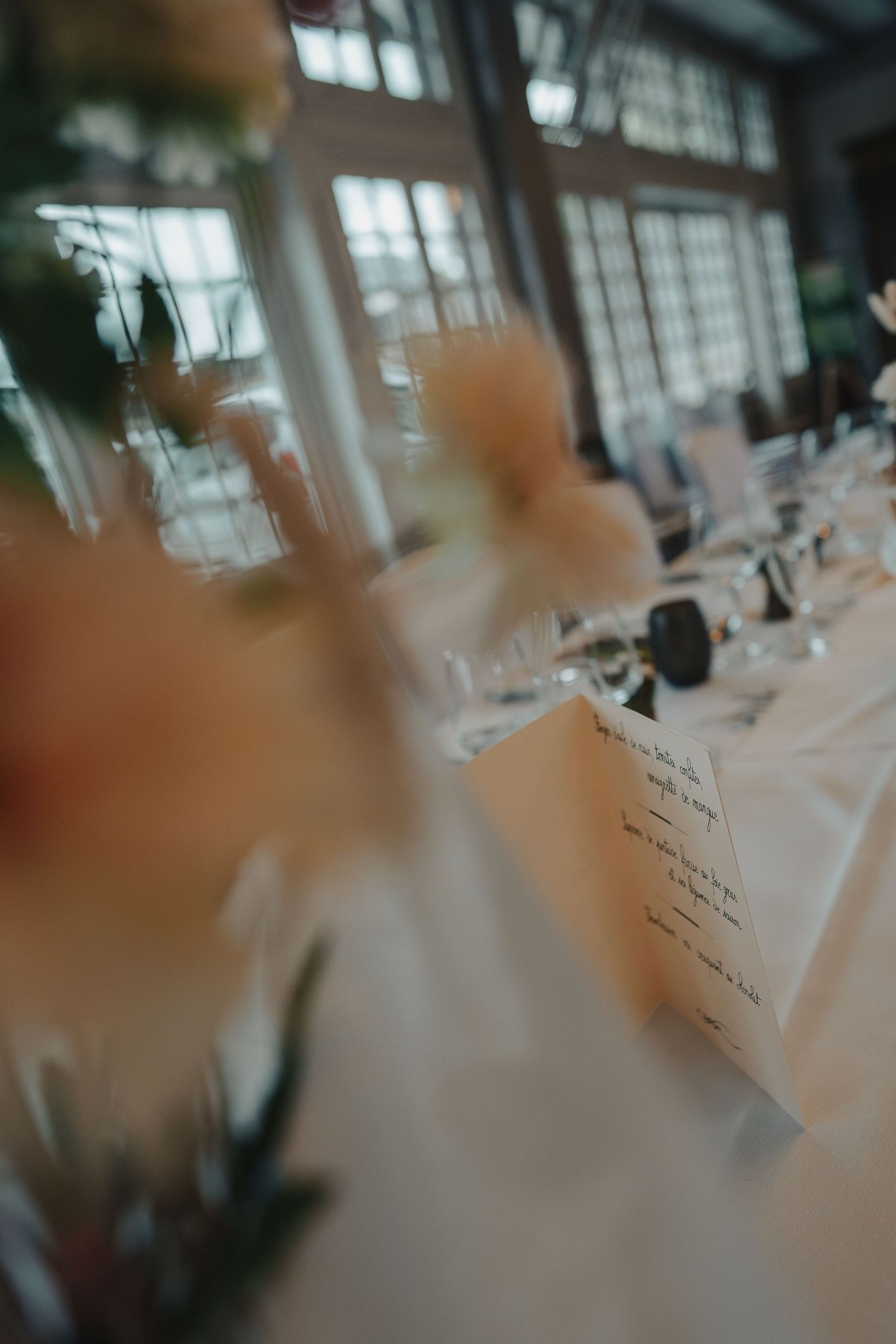 Wedding reception table settings with elegant place cards and soft focus details.