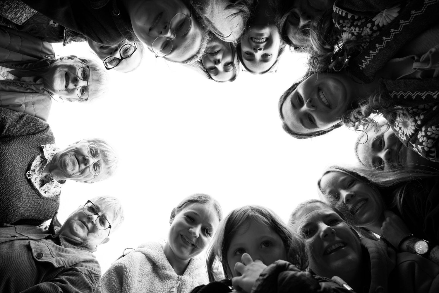 Black and white group photo taken from below with people looking down at the camera.