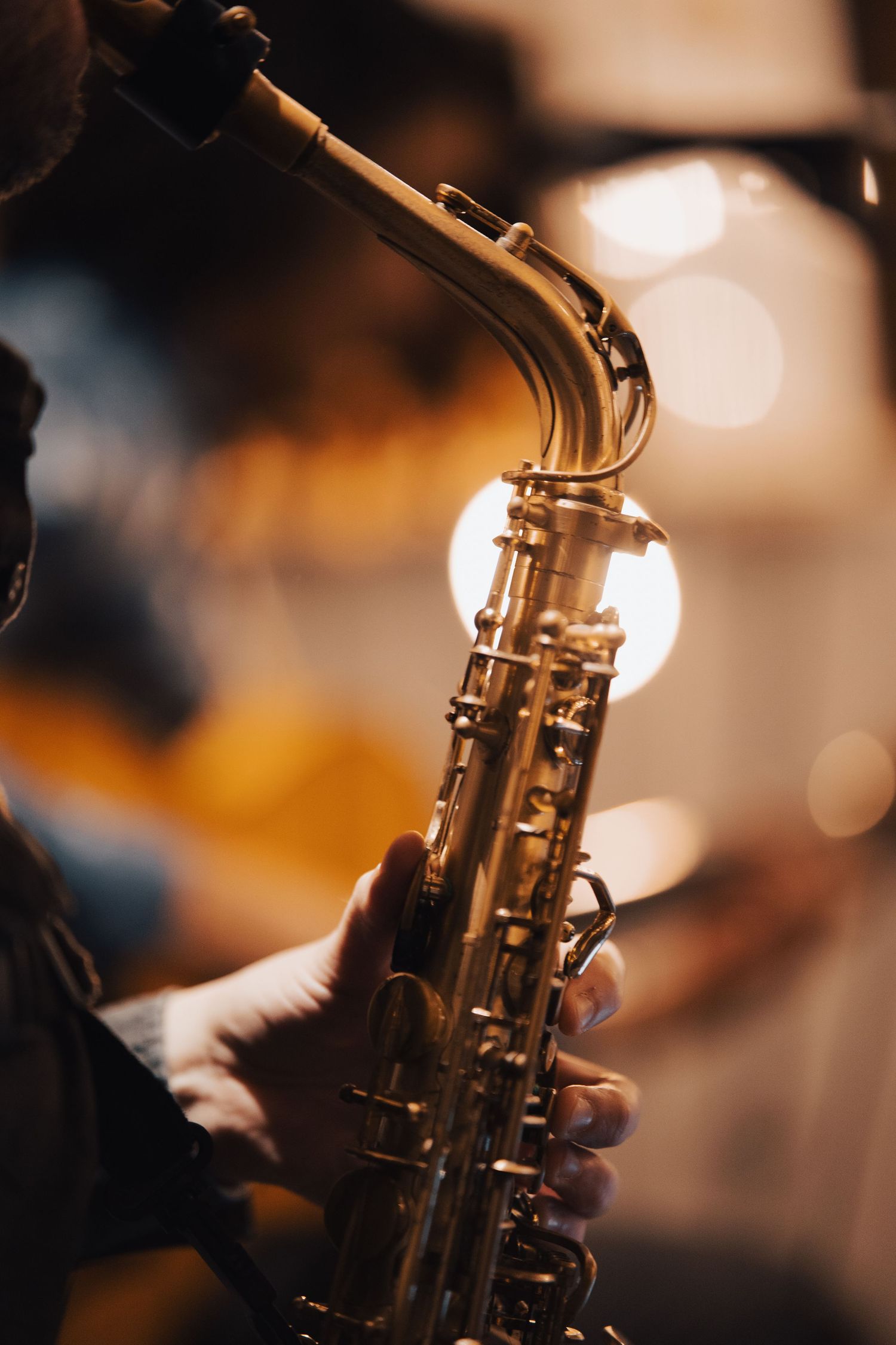 Close-up shot of a saxophone with warm bokeh lighting in the background.