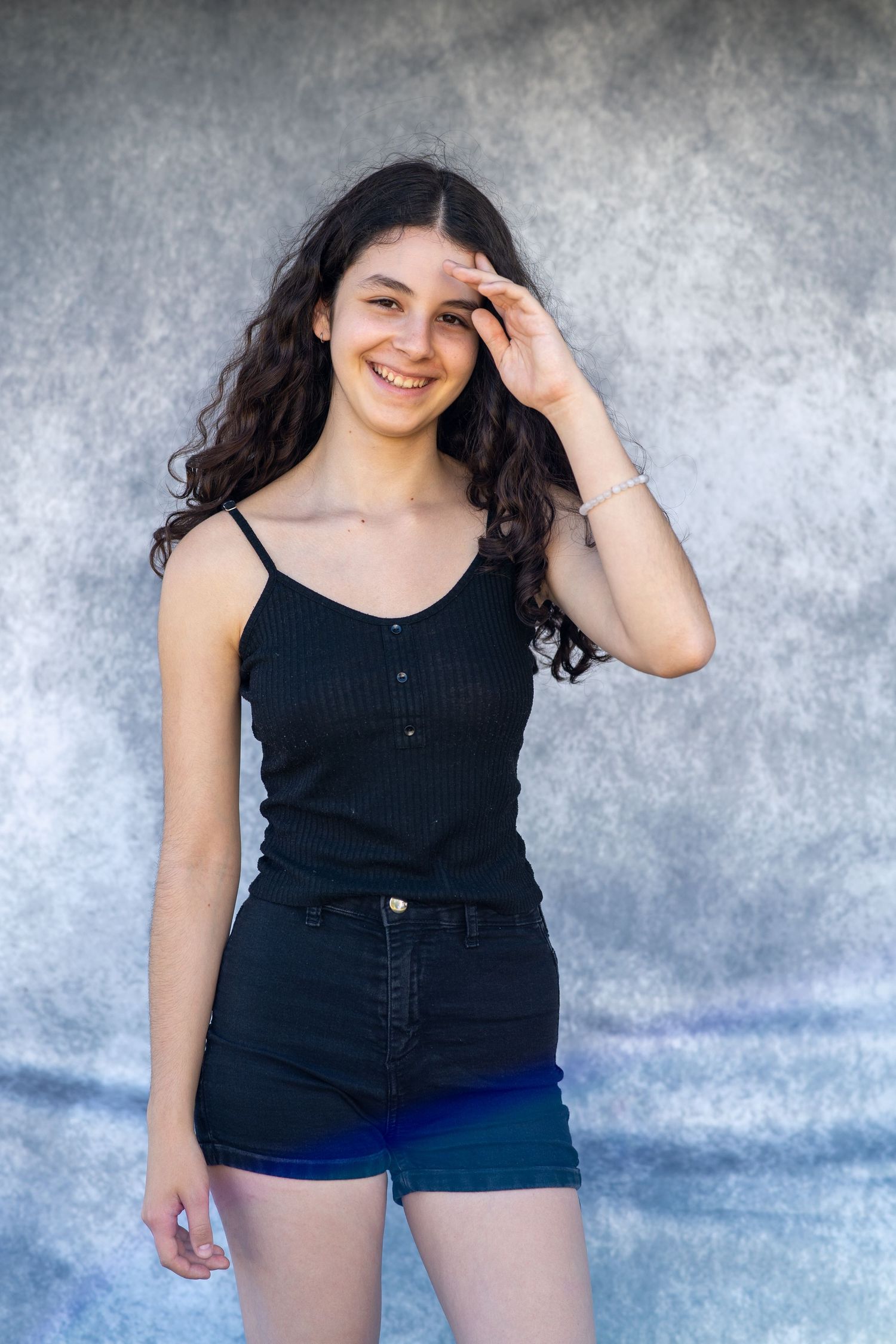 Casual portrait series against textured grey wall background.