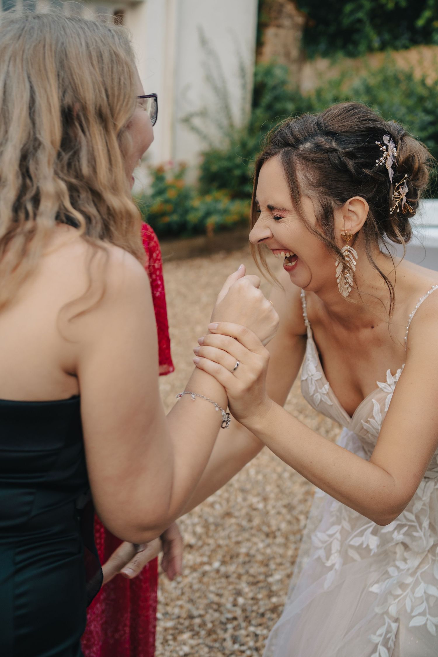 Bridesmaids in red dresses sharing laughter and joy during a wedding celebration.