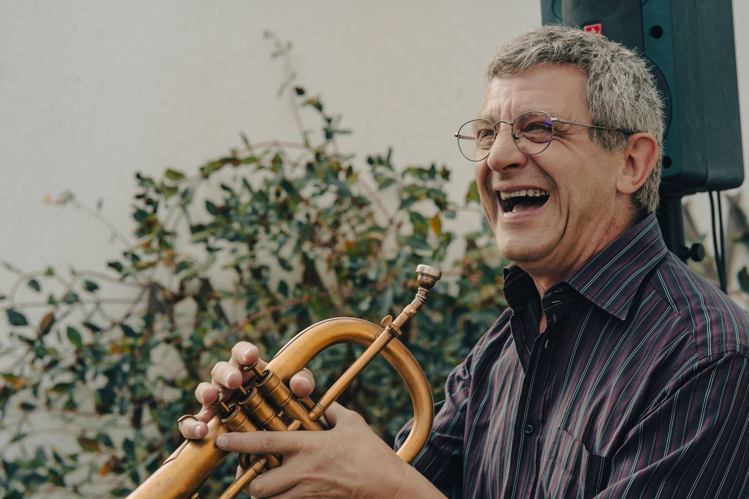 Musicians performing with brass instruments at an outdoor event.