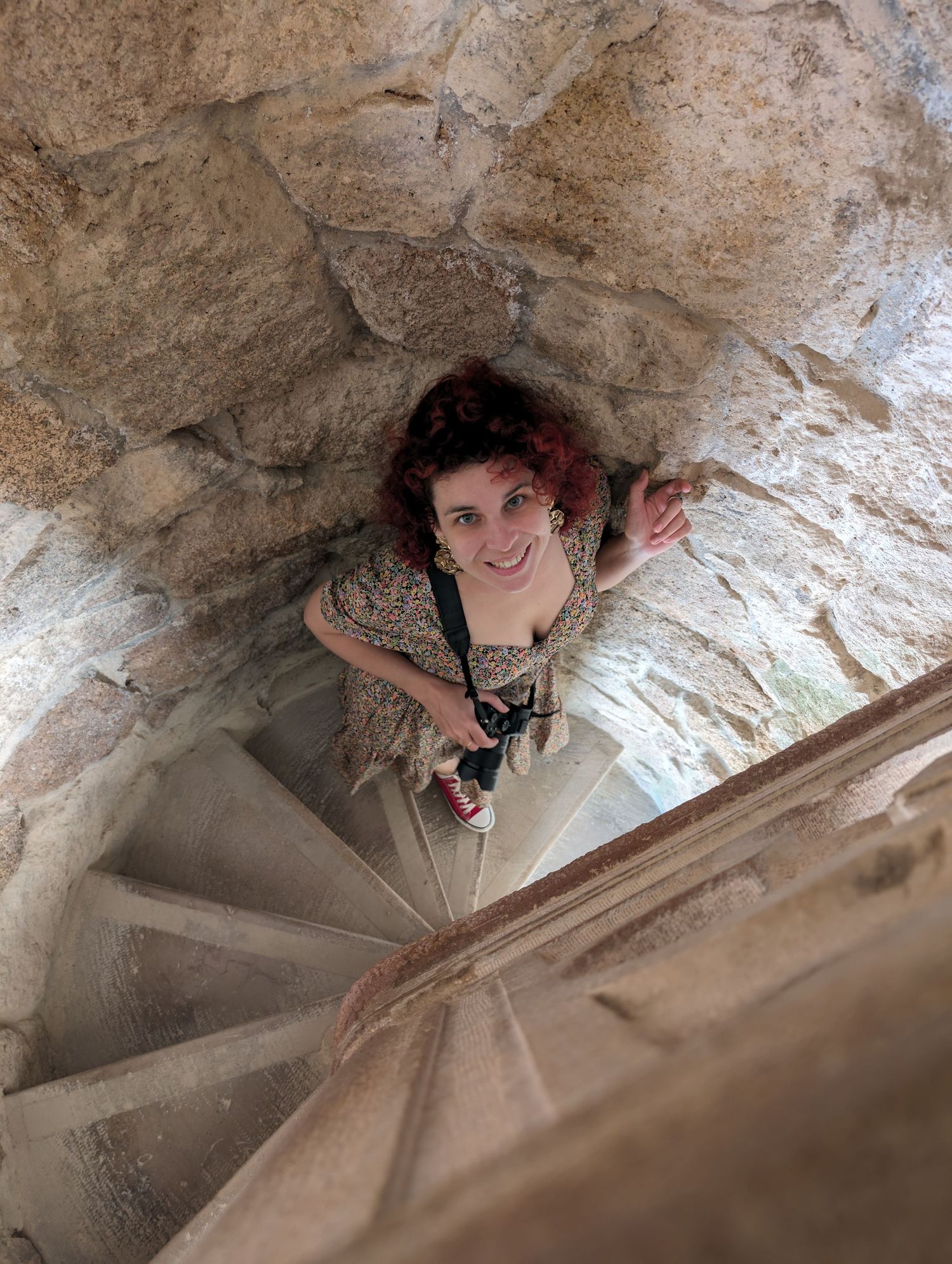 Looking down at climber ascending through narrow cave passage.