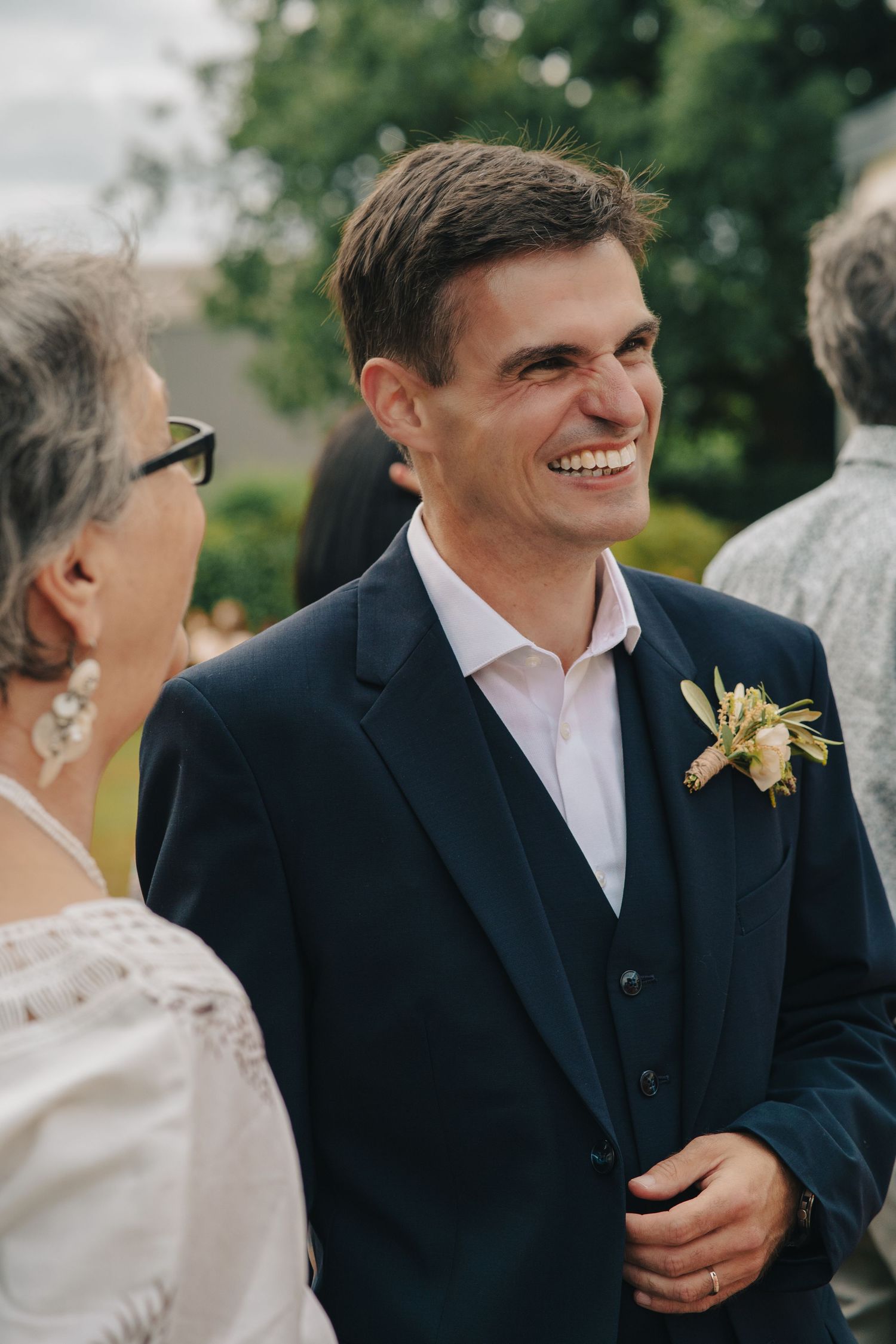 Wedding party members sharing joyful moments during an outdoor celebration.