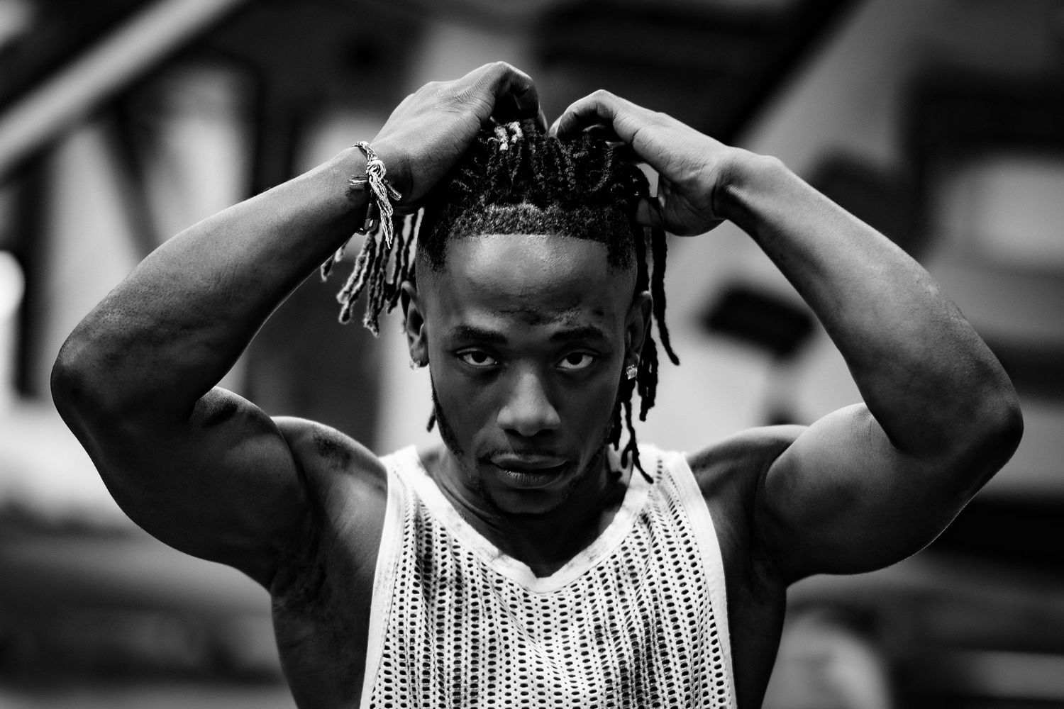 Artistic black and white portrait showing person in sleeveless top.