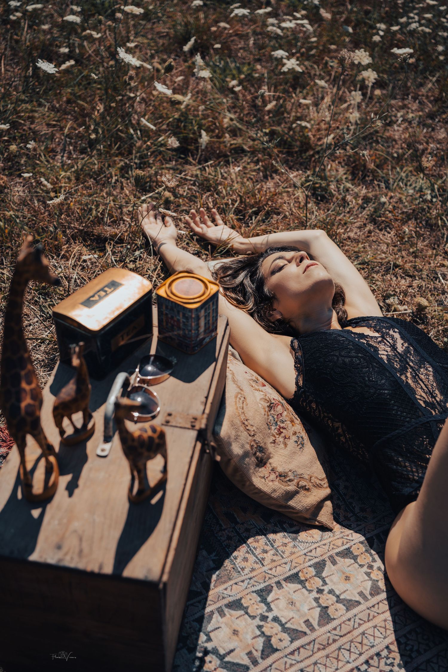 A dreamy outdoor portrait with vintage props and natural lighting among dried flowers.