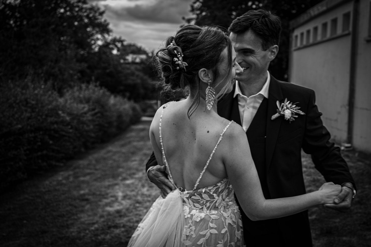 Romantic black and white wedding photo series showing intimate moments between a couple outdoors.
