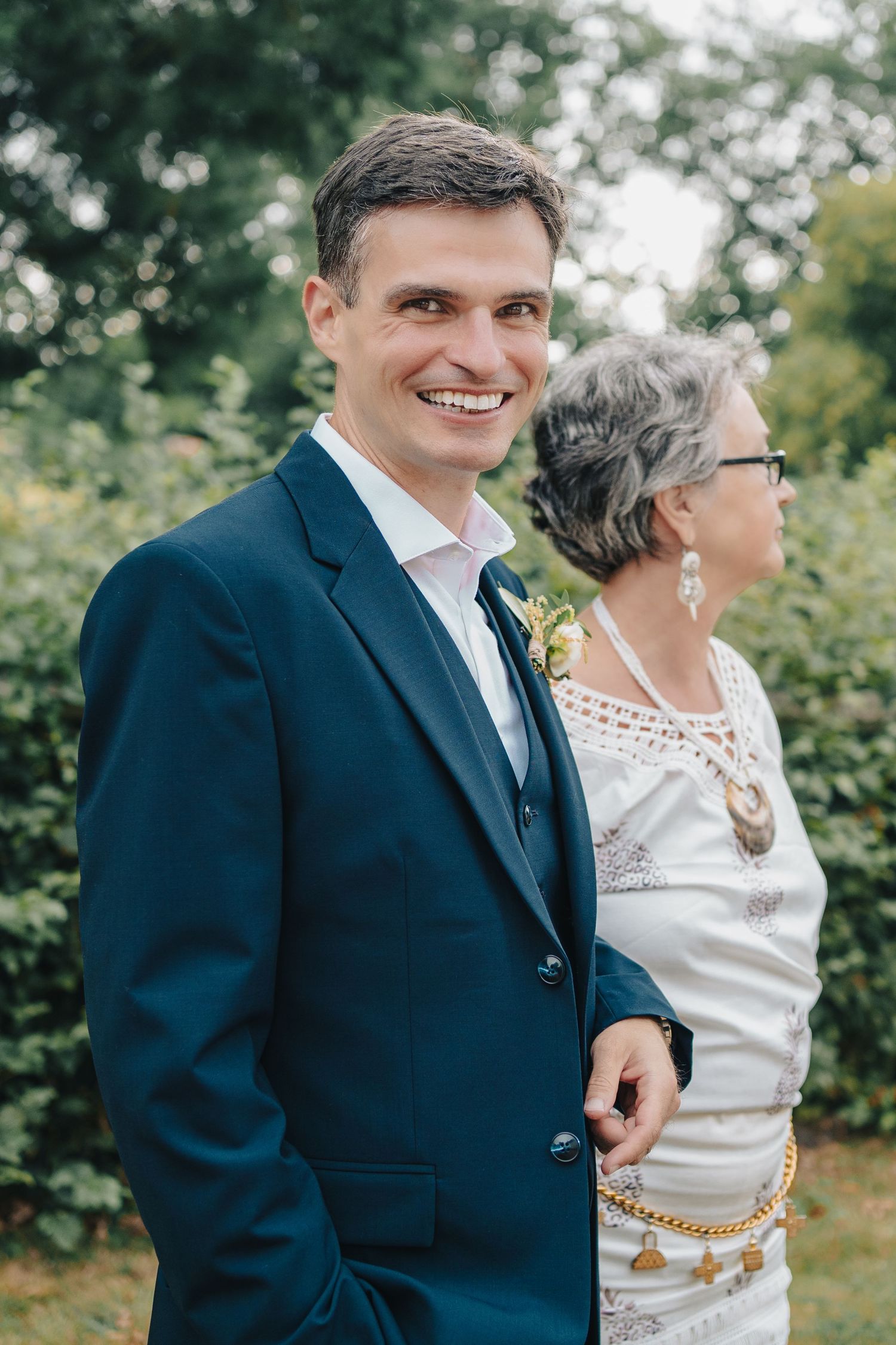 A couple in formal attire sharing a candid moment outdoors during their wedding.